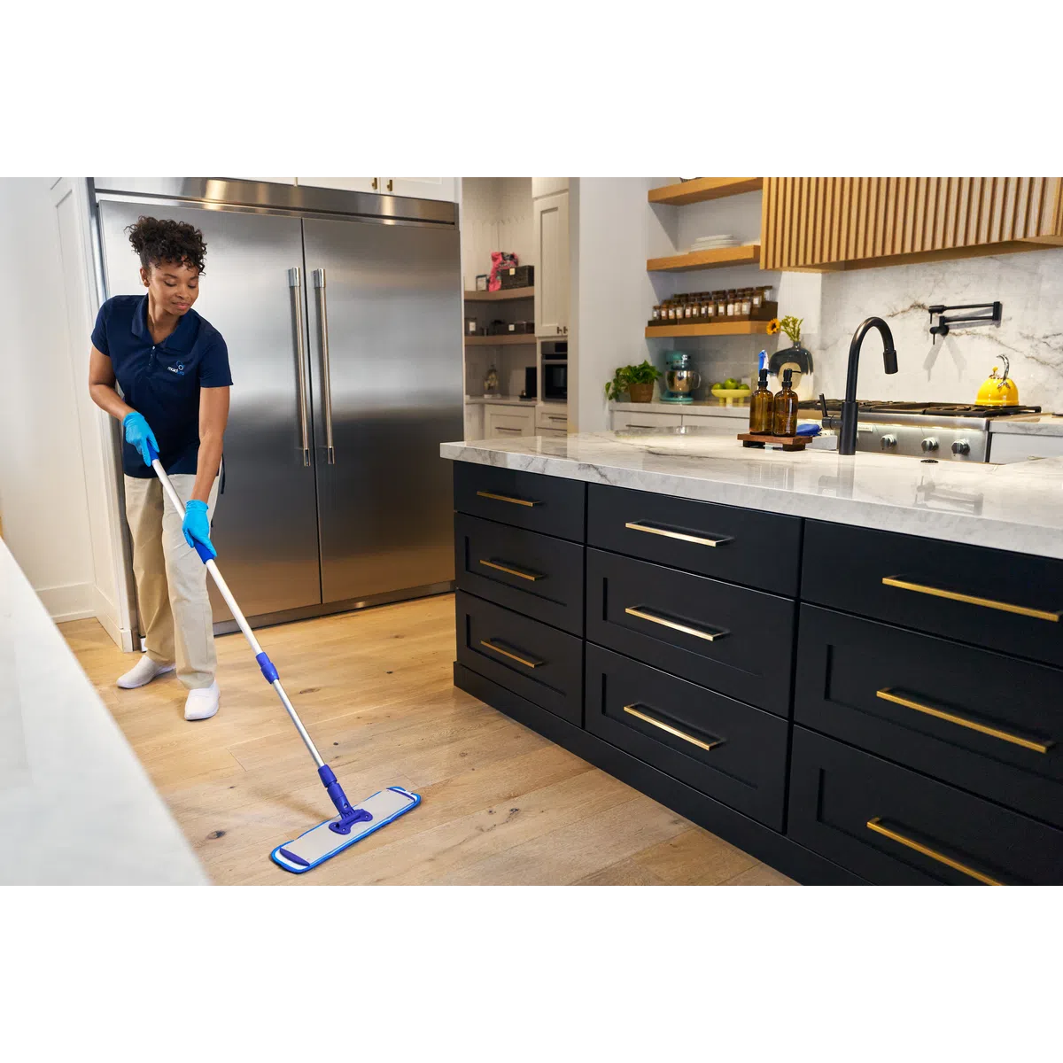 MaidPro Friendswood house cleaner mopping a kitchen floor in Texas