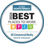 Atlanta Business Chronicle 2026 Best Places to Work badge for SK Commercial Realty with overlaid text and colorful flags.