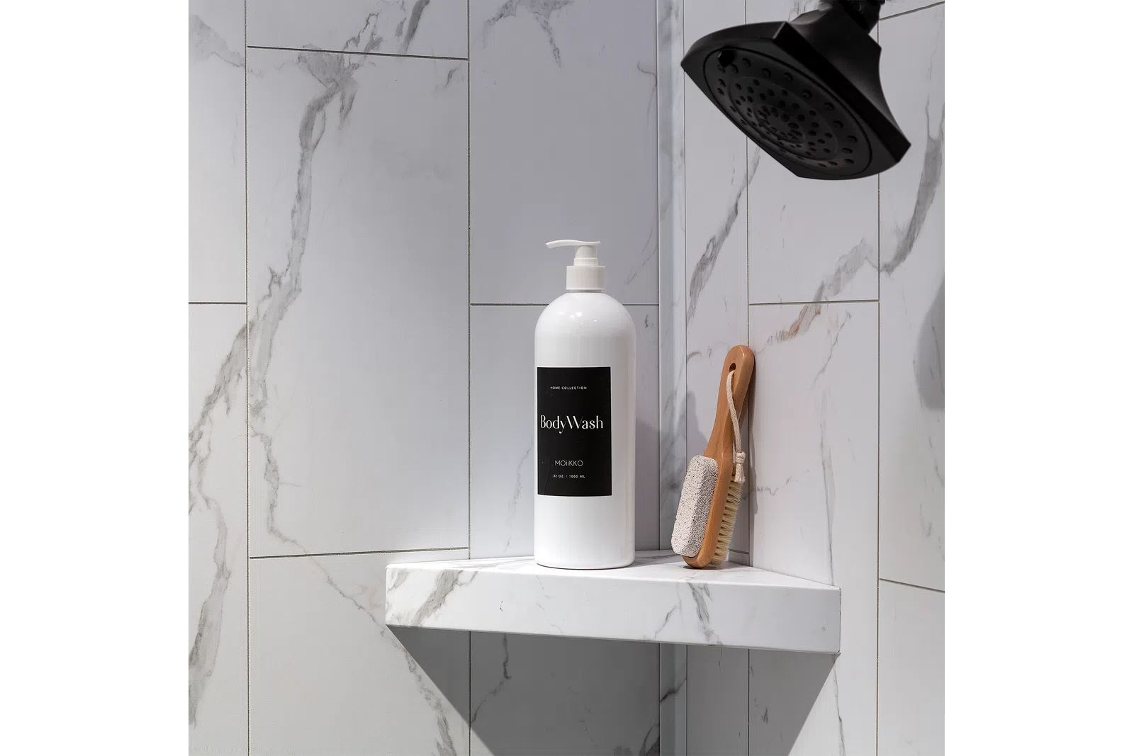 White body wash bottle and wooden brush on marble shower shelf under black showerhead in modern bathroom