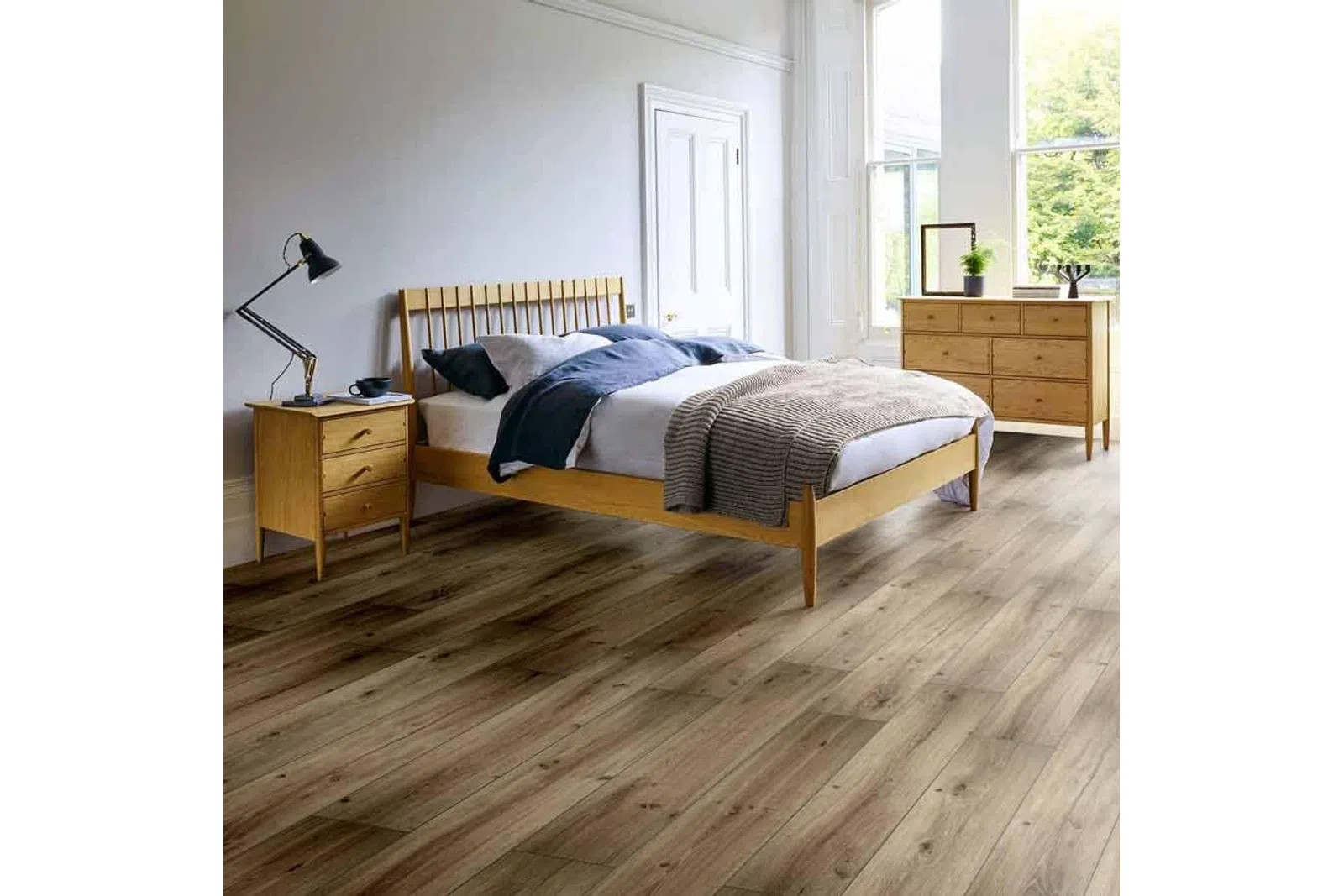 Modern bedroom with wooden bed frame, hardwood floor, dresser, nightstand, and natural light from large windows.