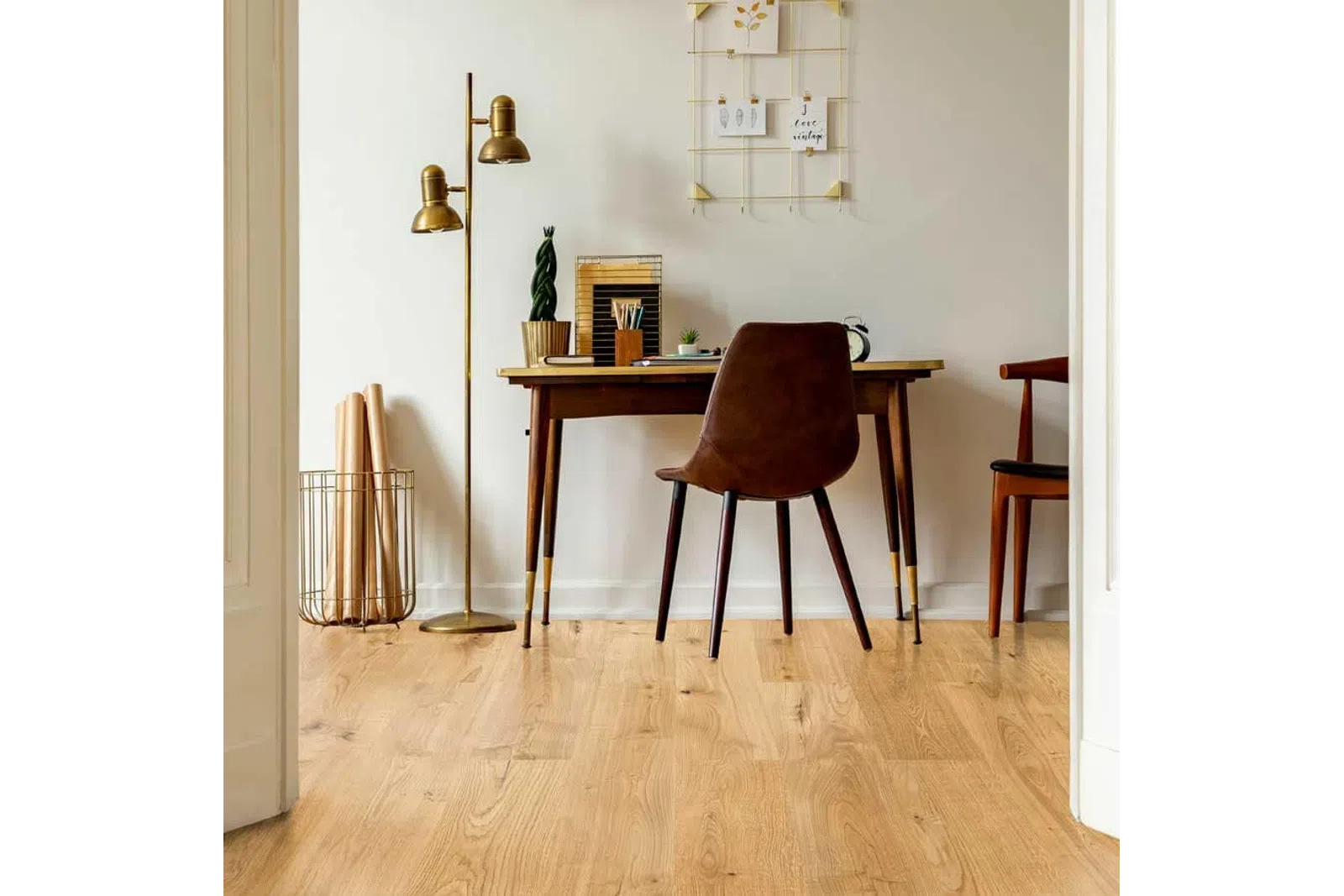 Cozy home office with wooden desk, brown chair, gold floor lamp, and decorative wall grid in minimal style