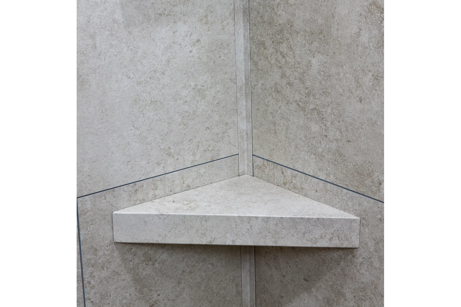 Triangular stone corner shelf mounted on beige tiled wall with subtle texture and grout lines