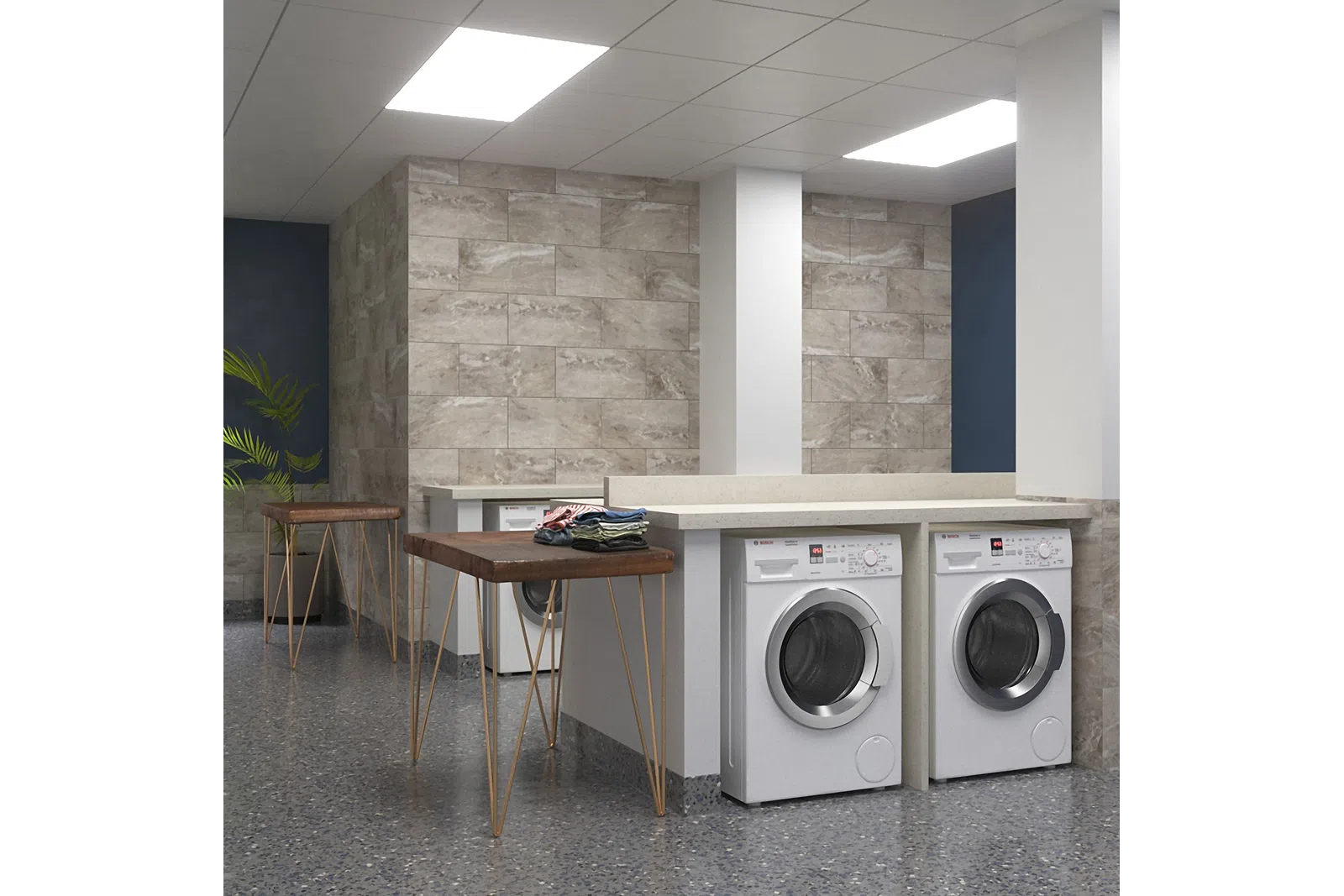 Modern laundry room with front-load washers, stone tile walls, wooden folding tables, and bright overhead lighting