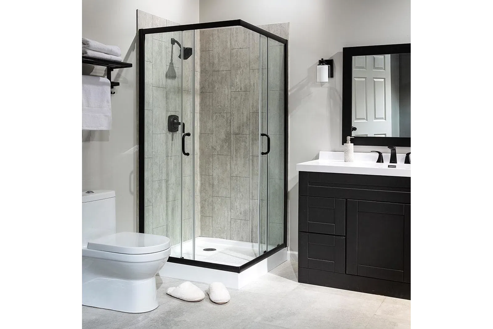 Modern bathroom with glass shower enclosure, black vanity, toilet, and neutral tile flooring and walls.