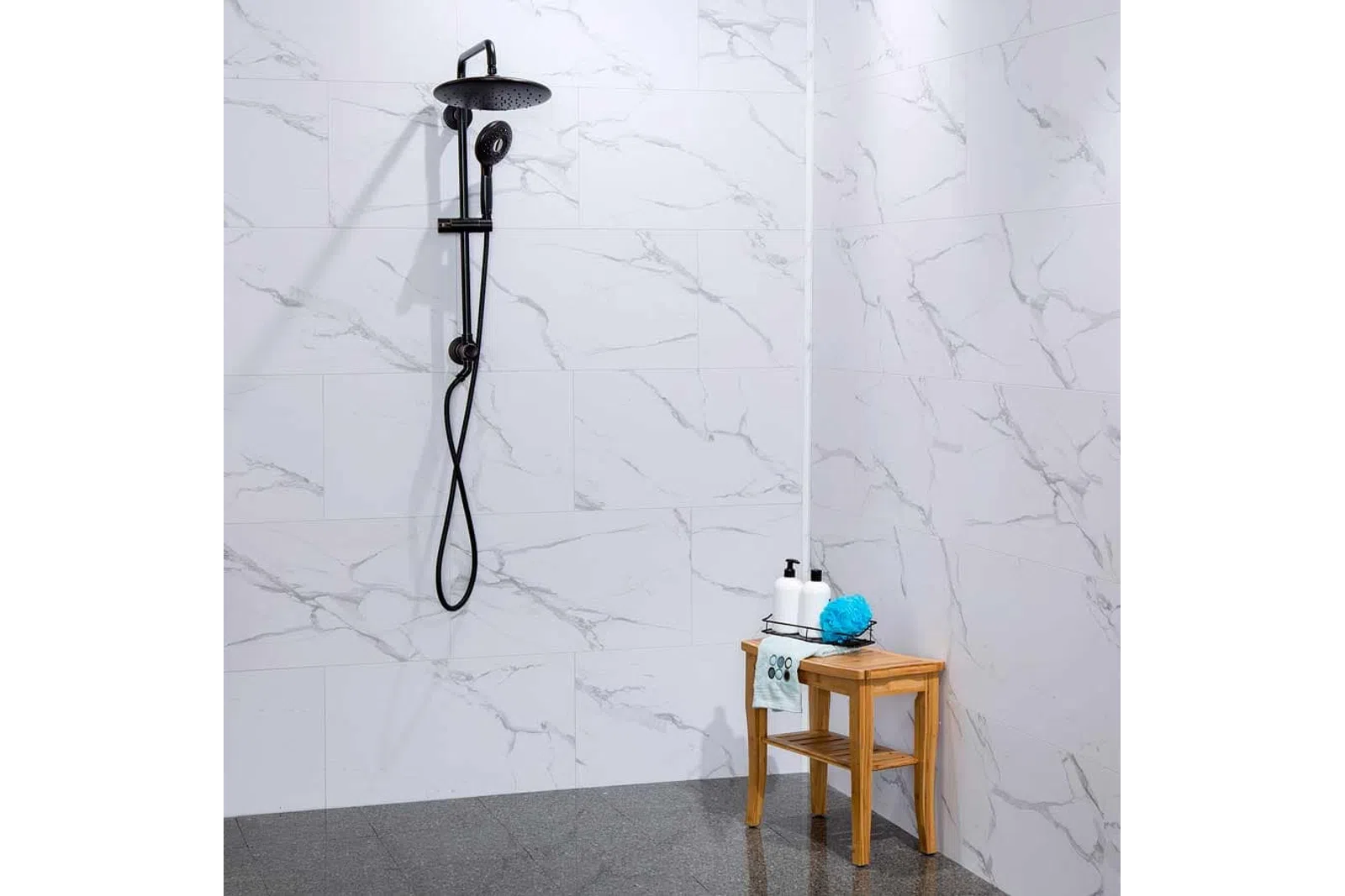 Modern shower with black fixtures and marble wall tiles next to a wooden stool with toiletries and a blue sponge.