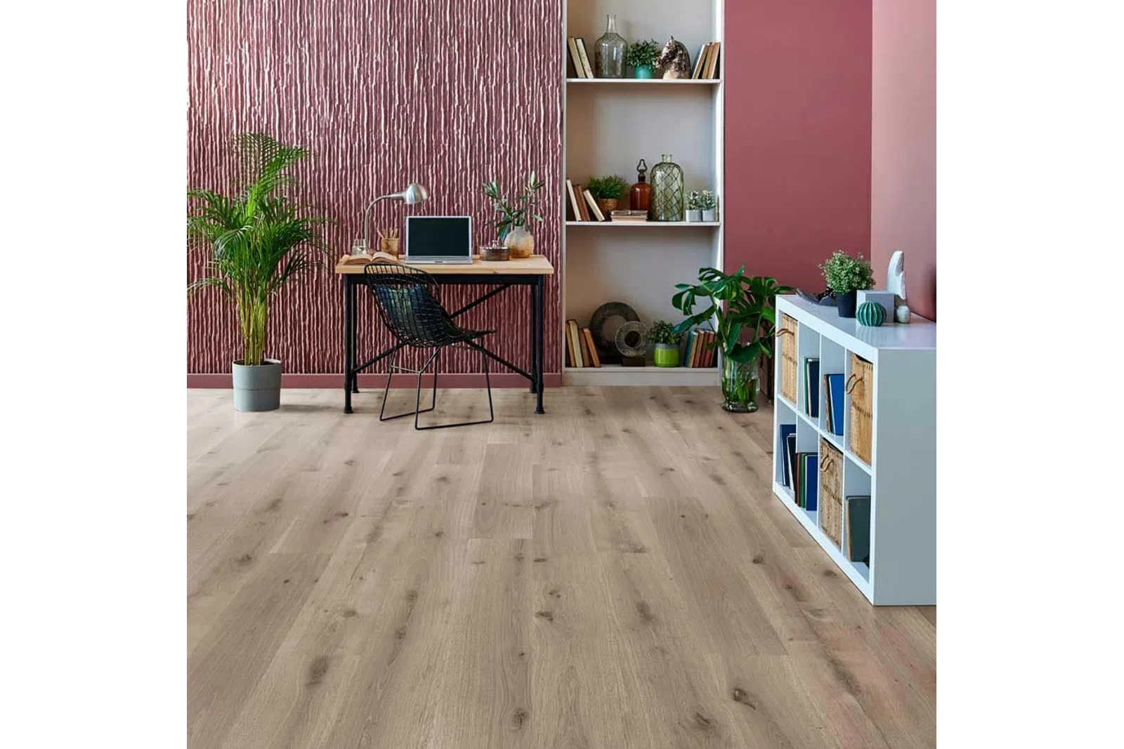 Modern home office with light wood flooring, textured mauve accent wall, plants, and minimalist furniture setup