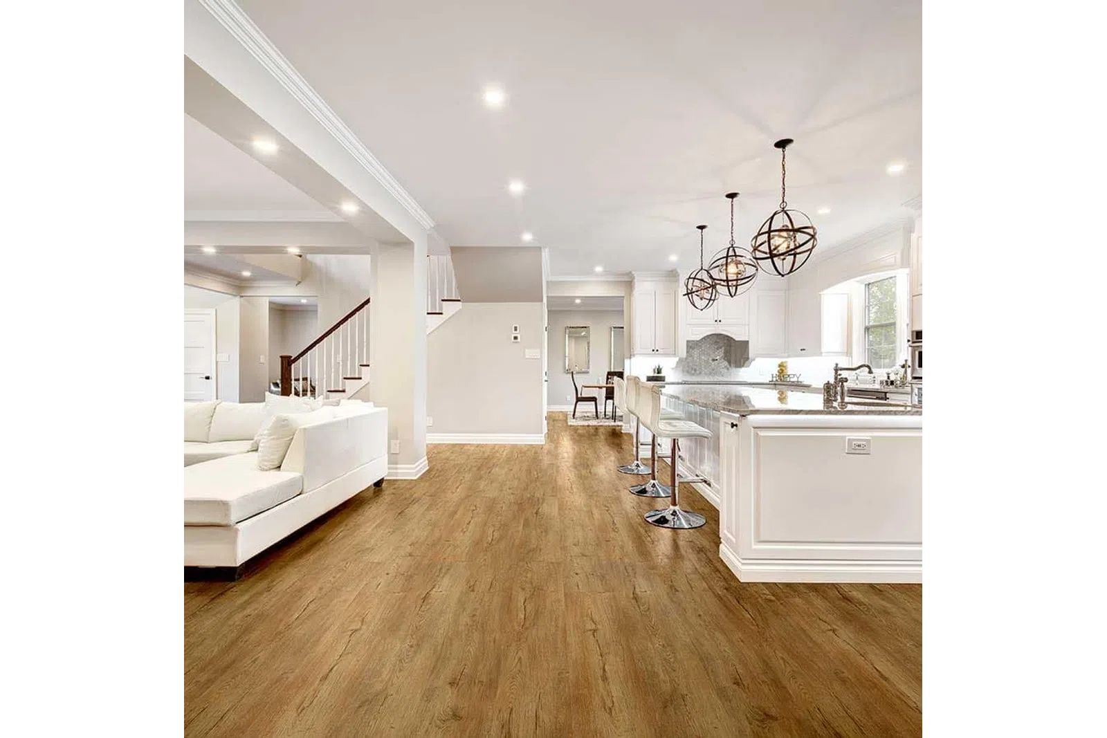 Open concept kitchen and living area with white cabinets, wood flooring, and modern pendant lights