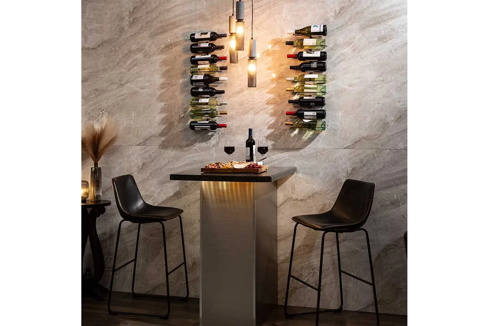 Modern wine bar setup with two black bar stools, wine bottles on wall racks, and a table with wine and snacks.