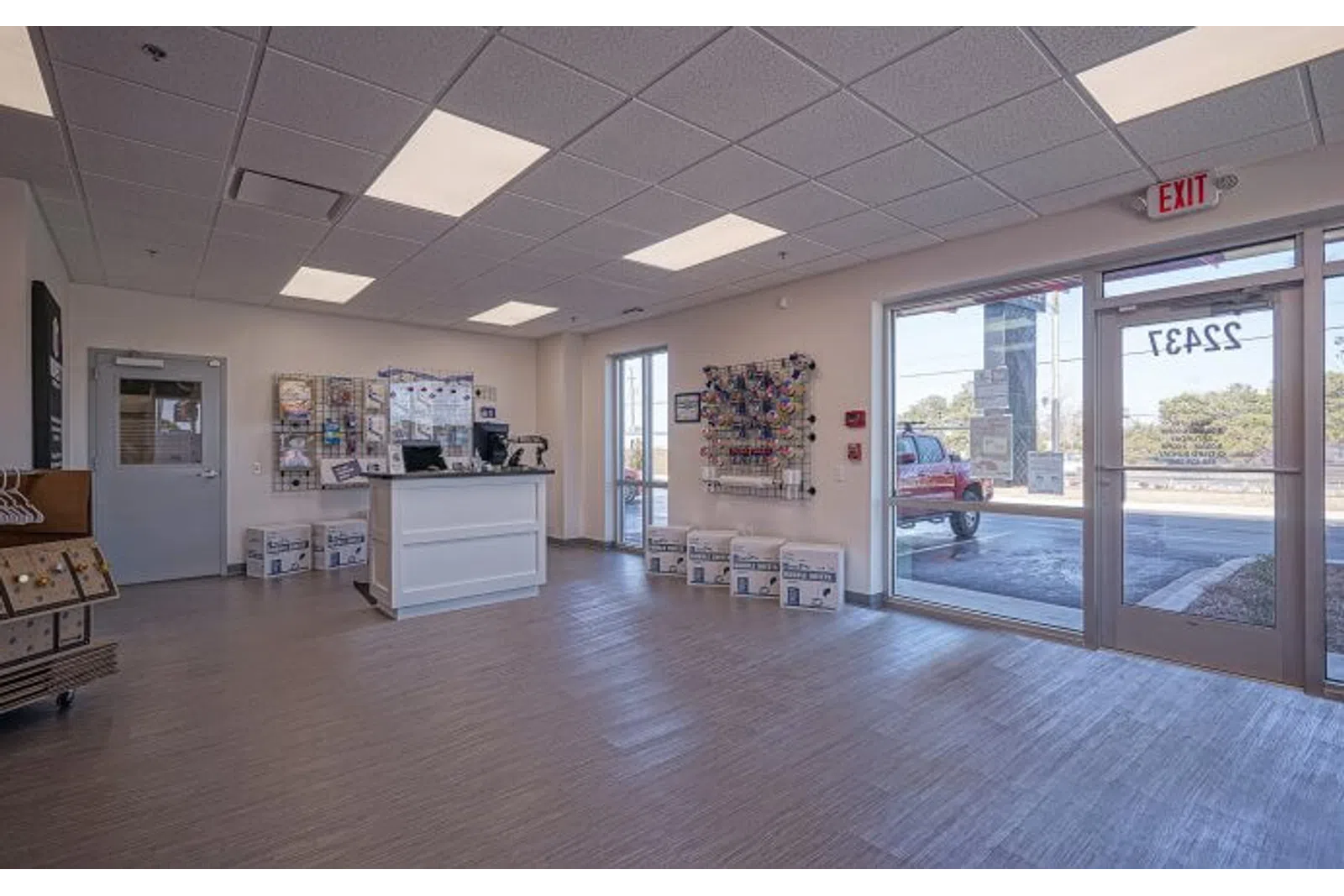 Bright, clean shipping store interior with counter, packing supplies, and large front windows showing outside view.