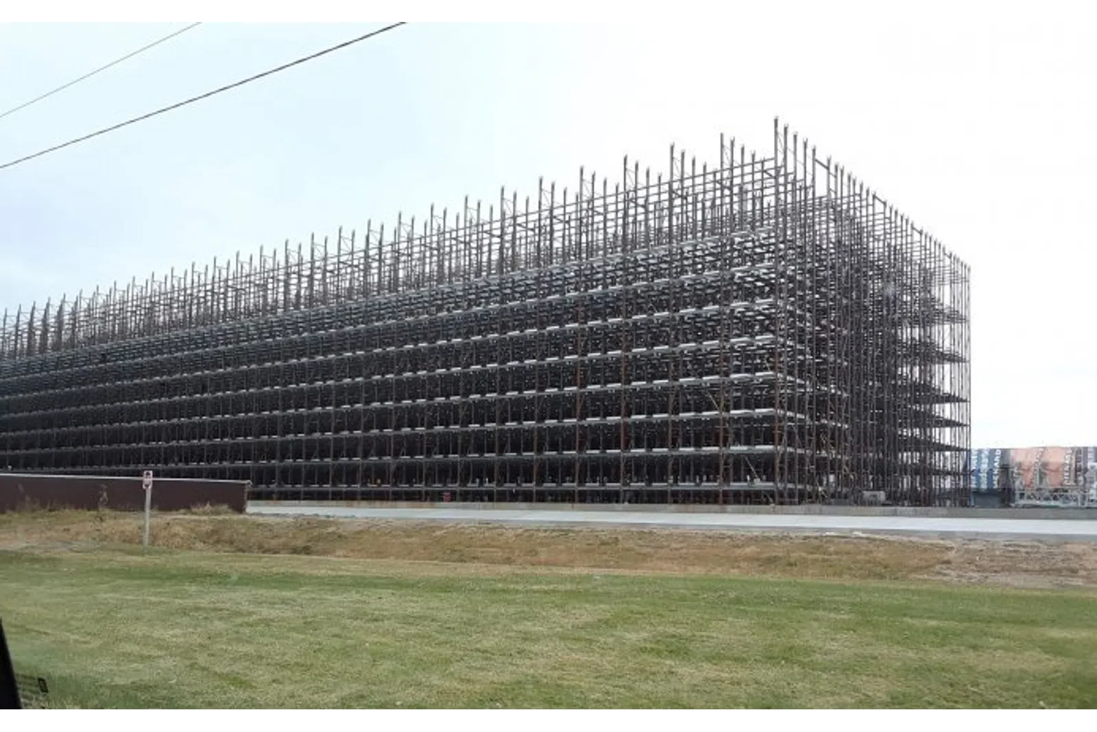 Large industrial metal rack storage structure outdoors with multiple levels and open framework