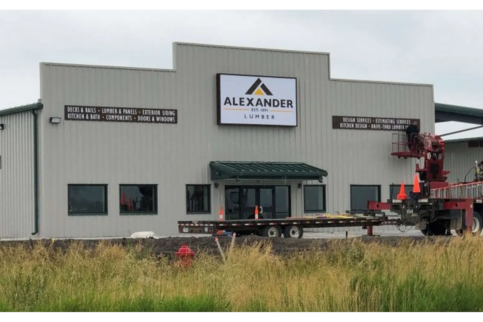 Alexander Lumber building with signage displaying services like decks, rails, kitchen design, and exterior siding