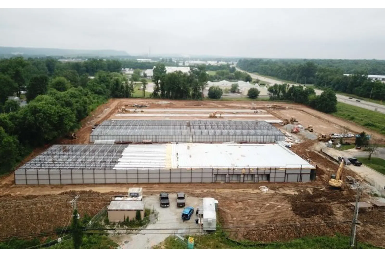 Aerial view of a large industrial building under construction with steel framework and foundation laid out.