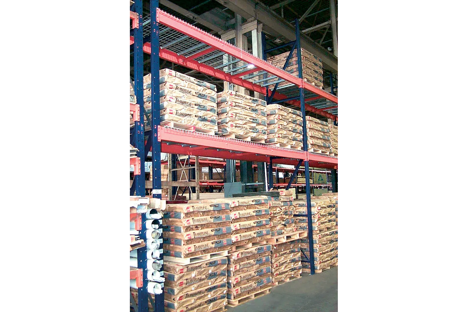 Warehouse shelves stocked with palletized bags of Timberline cement ready for distribution and storage.