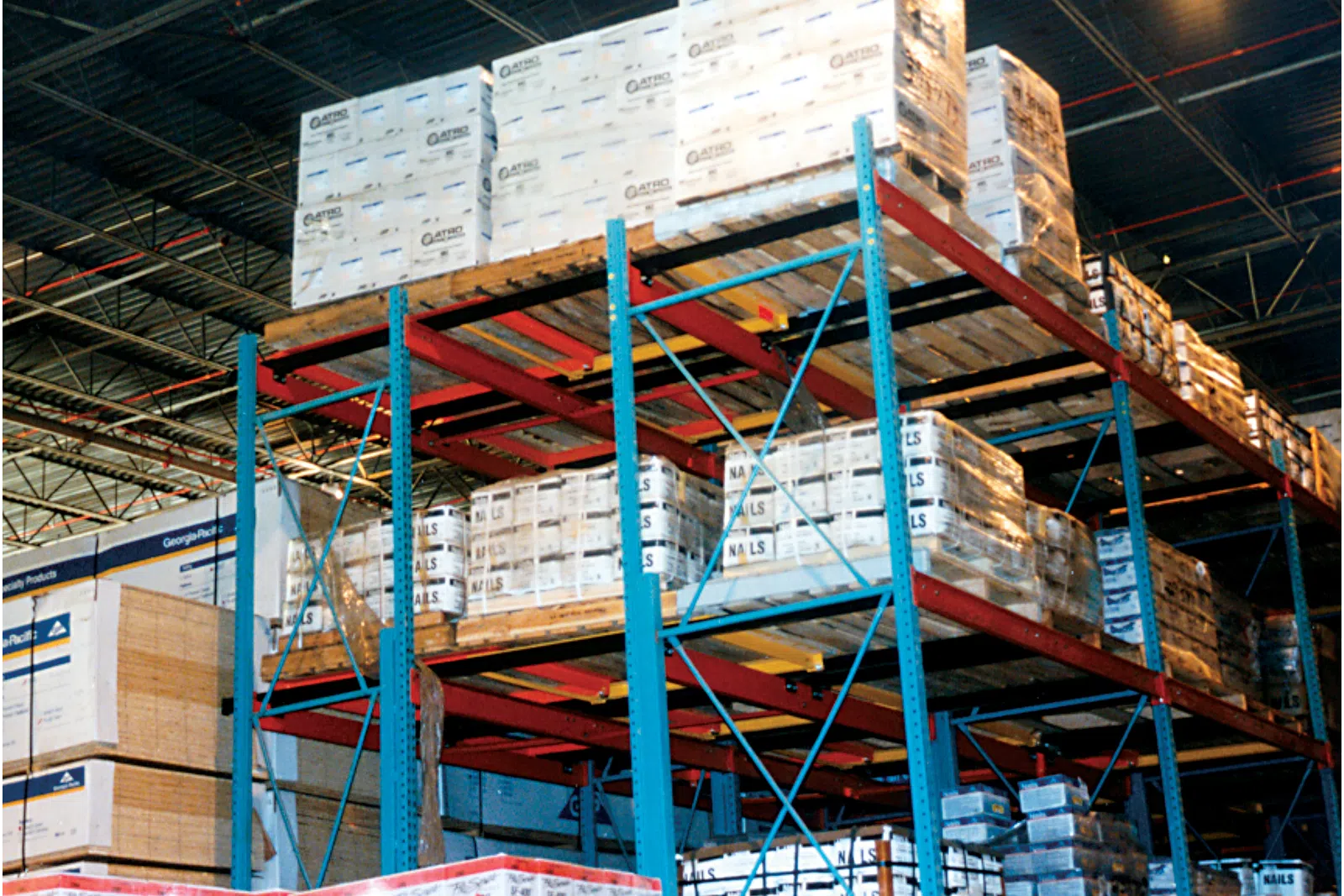 Warehouse shelving filled with pallets of packaged products stacked high in an industrial storage facility