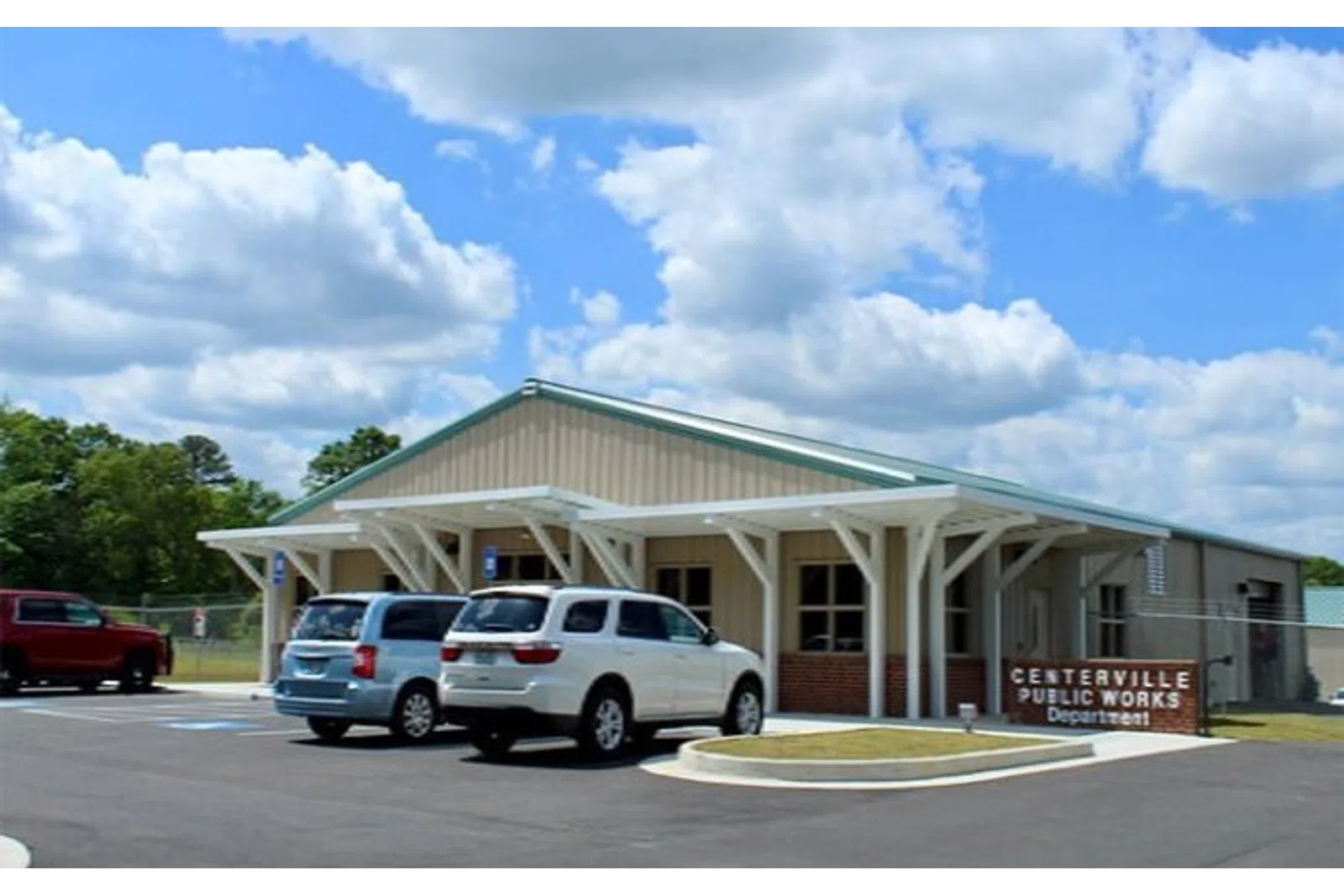 Centerville Public Works Department building with parked cars under blue sky and white clouds