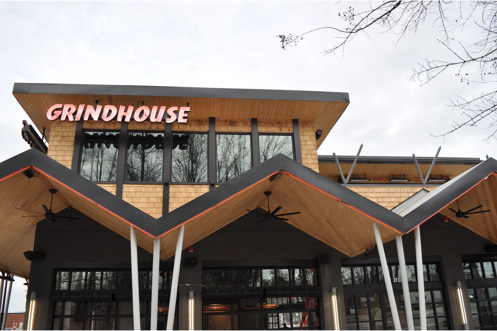 Modern Grindhouse cafe exterior with distinctive zigzag wooden roof and large windows on overcast day