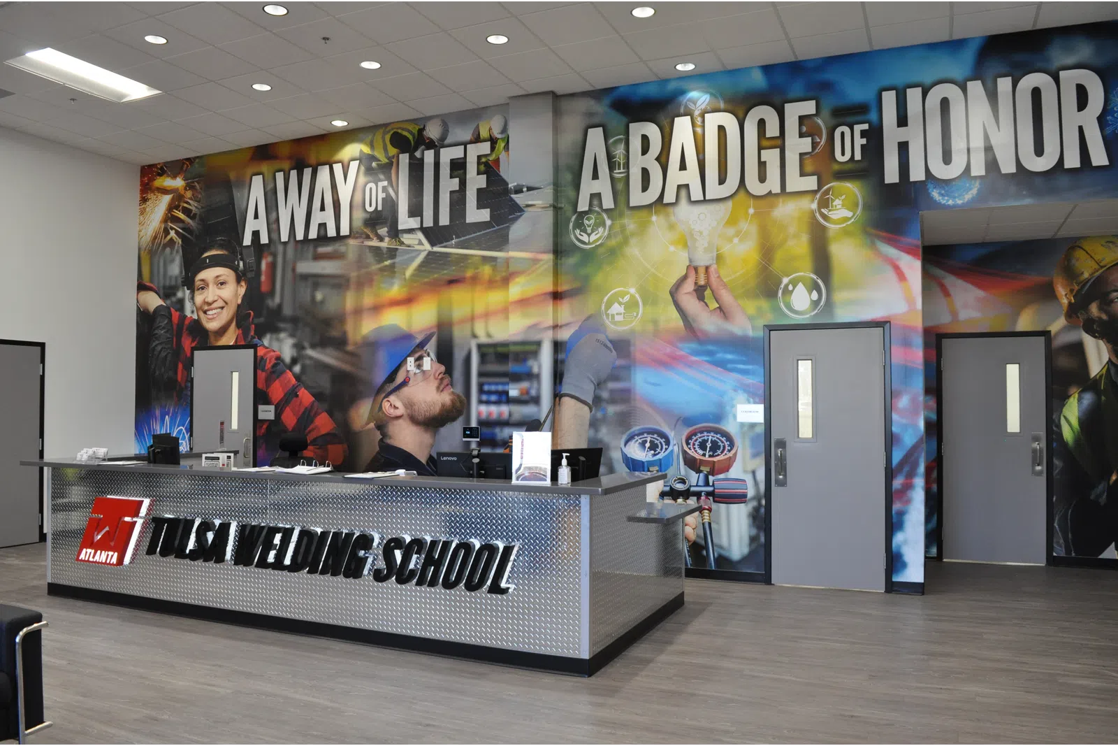 Reception area of Tulsa Welding School with a motto wall displaying A Way of Life A Badge of Honor.