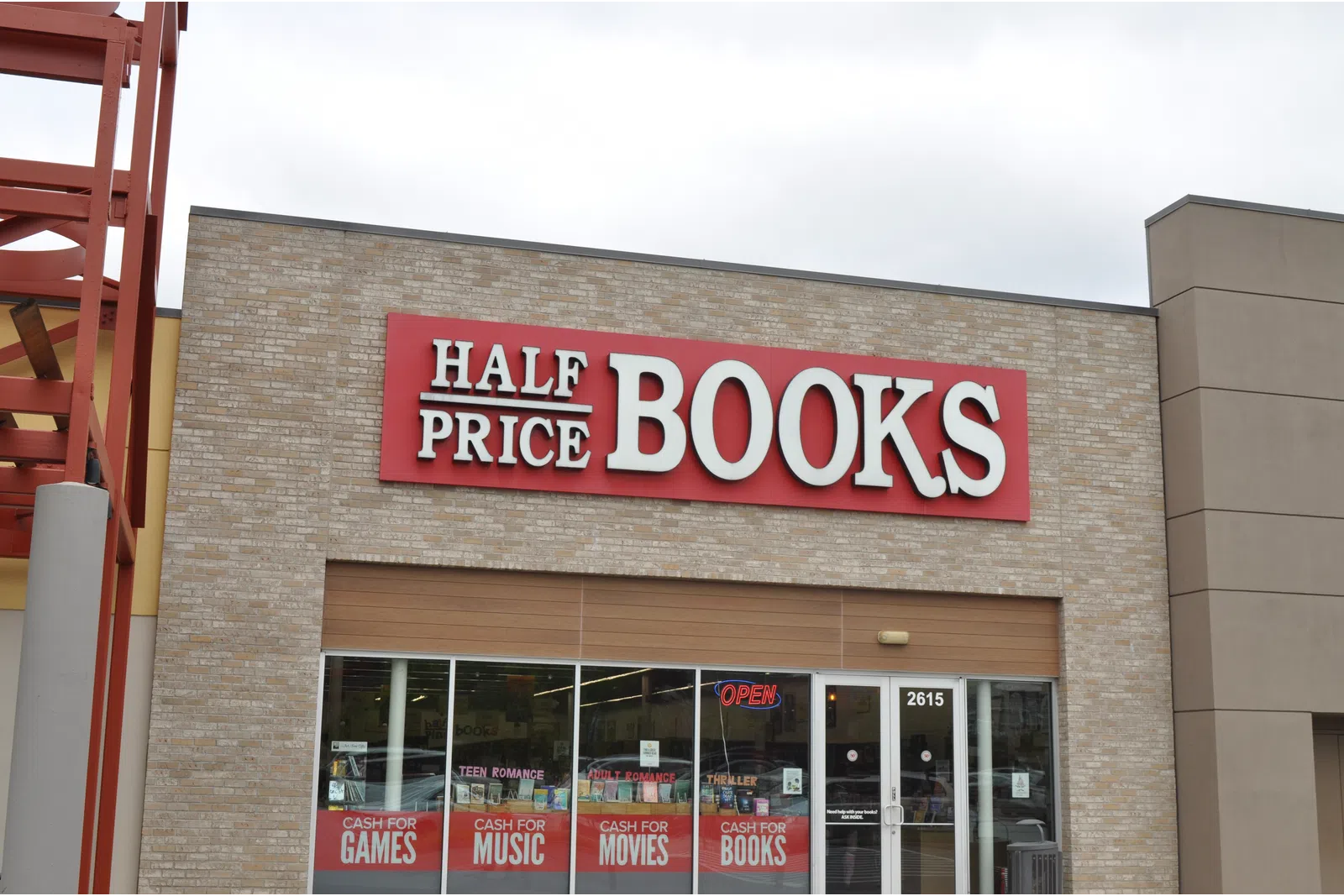 Exterior of Half Price Books store with signage advertising cash for games, music, movies, and books.