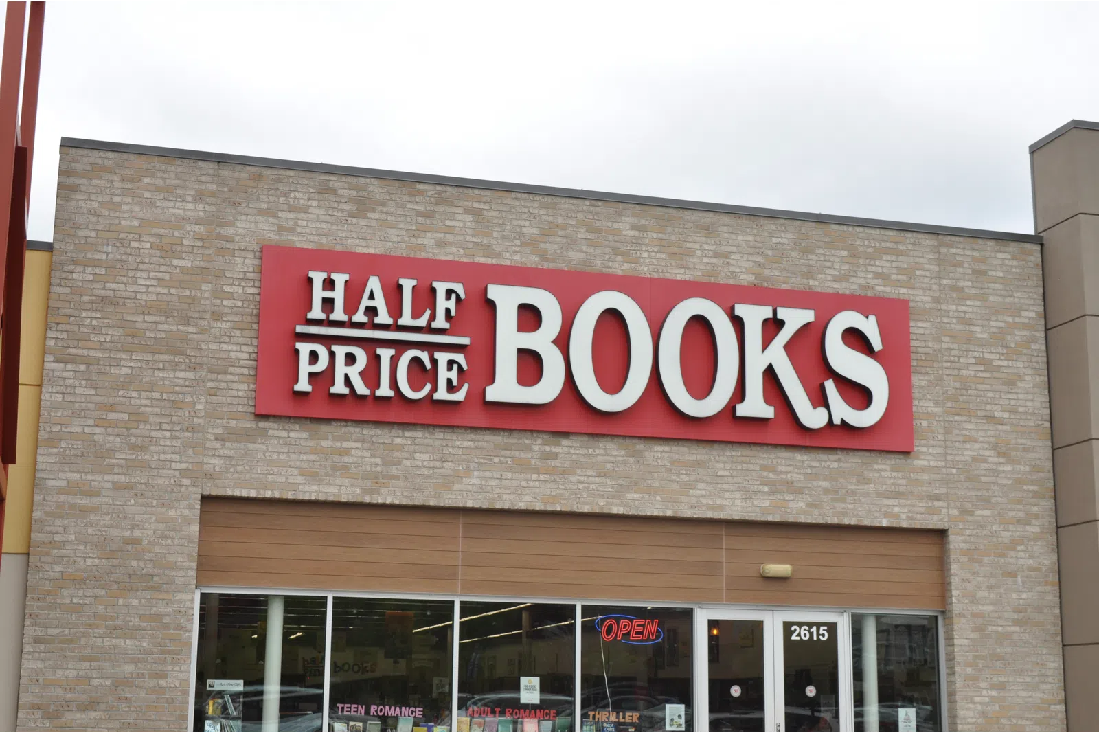 Half Price Books store front with red sign and glass windows showing book sections inside