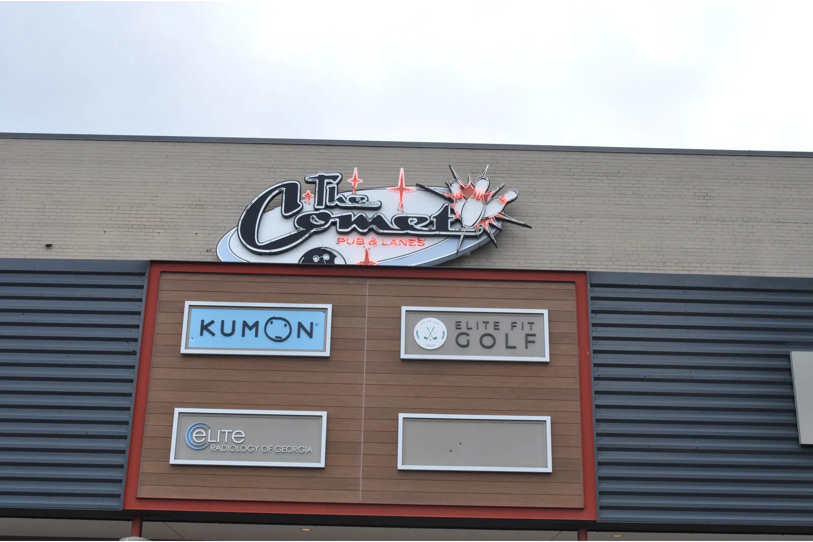 Storefront signs for Kumon, Elite Fit Golf, Elite Radiology of Georgia, and The Comet Pub & Lanes on a commercial building.