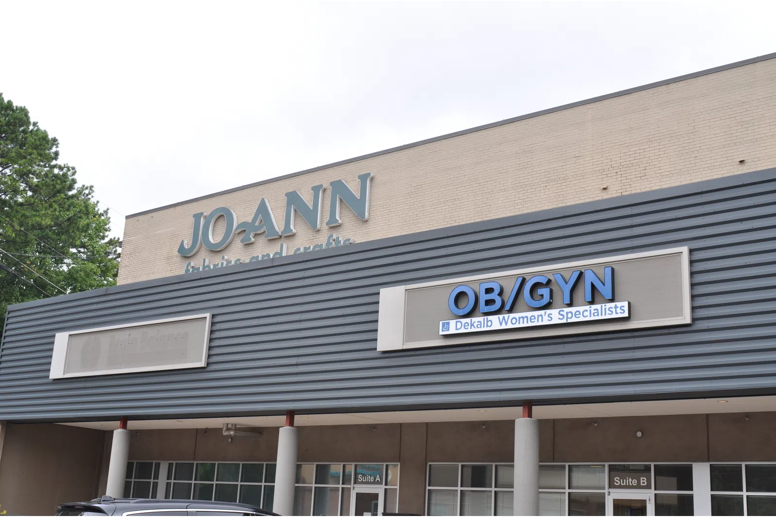 Exterior of a building with JO-ANN Fabrics and Crafts and OB/GYN Dekalb Women’s Specialists signs.