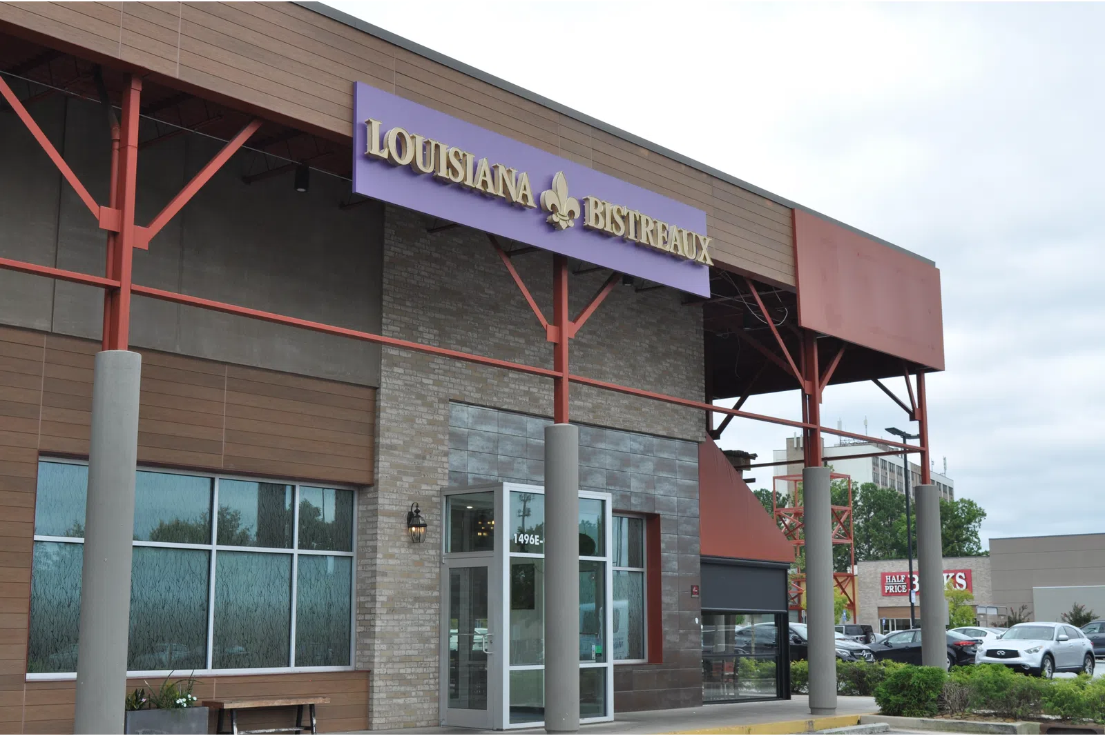 Exterior view of Louisiana Bistreaux restaurant with purple sign and modern architectural design.