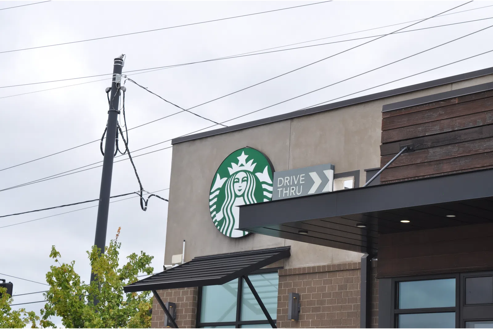 Starbucks coffee shop exterior with drive-thru sign on a cloudy day