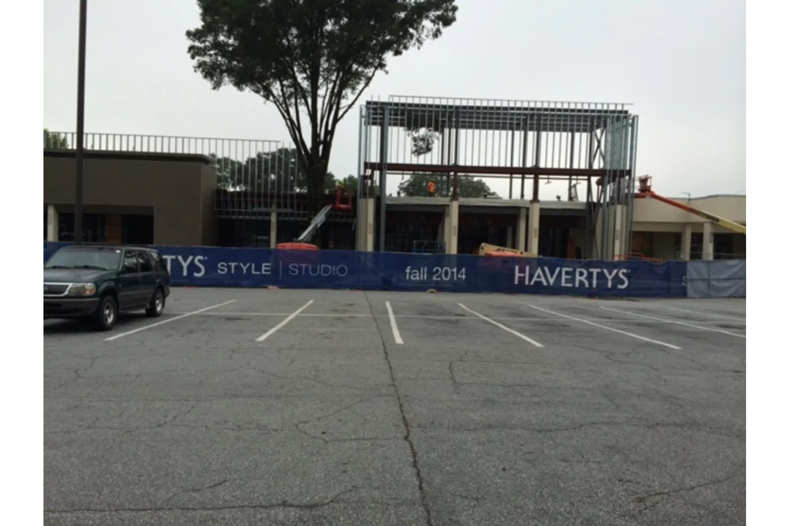 Construction site with steel framework and Havertys banner advertising Style Studio fall 2014 near empty parking lot.