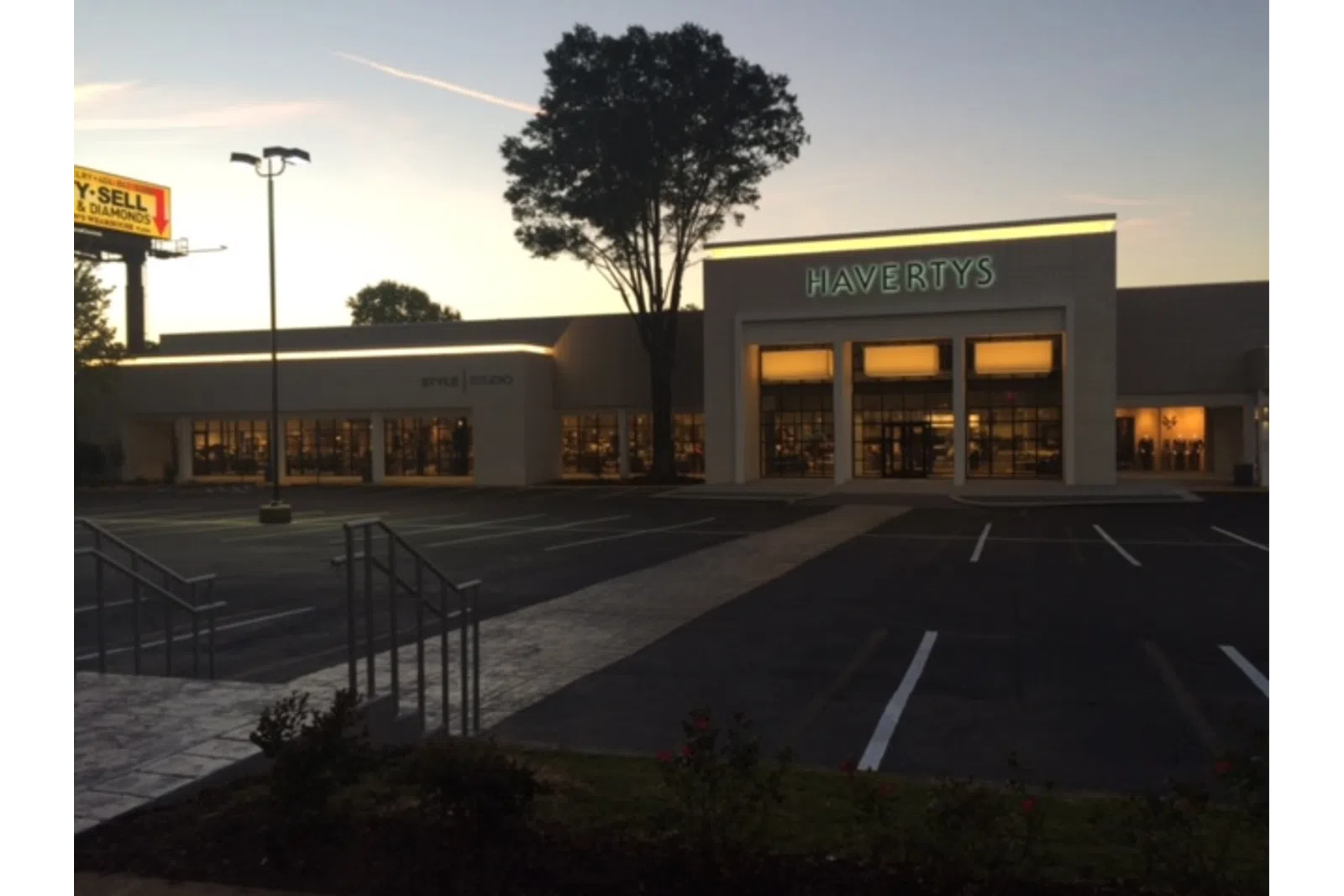 Havertys furniture store at dusk with illuminated signage and empty parking lot in front.