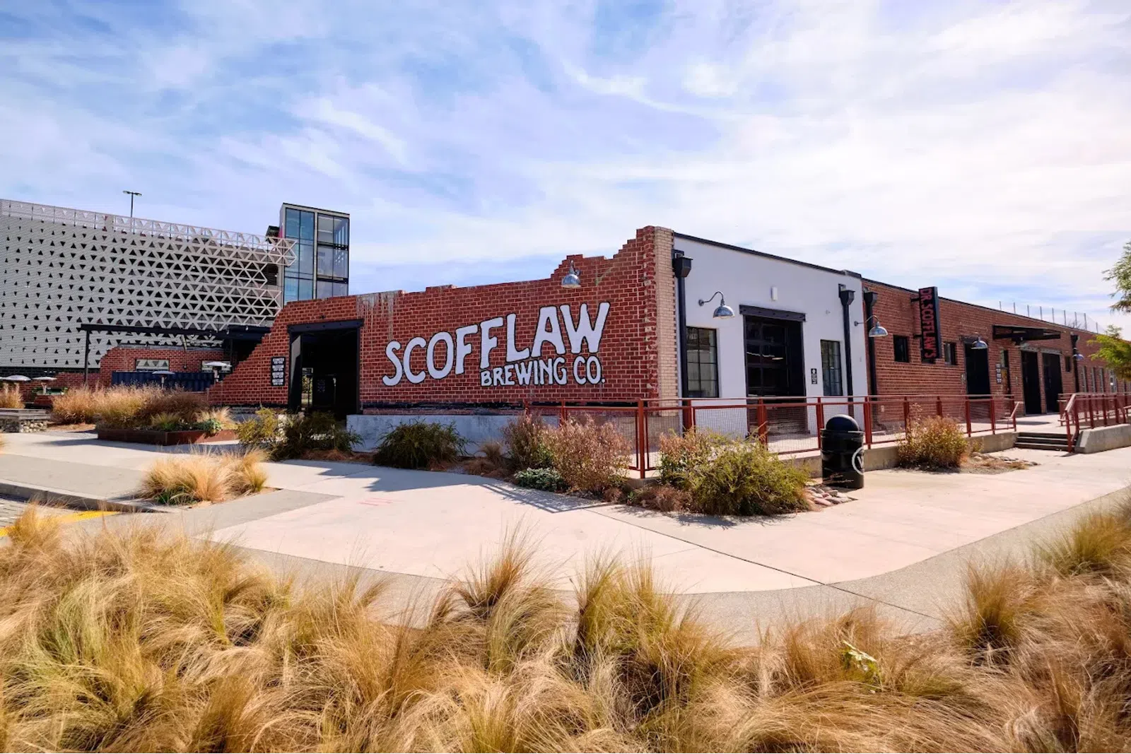 Scofflaw Brewing Co. brick building with outdoor landscaping and clear sky in an urban setting.