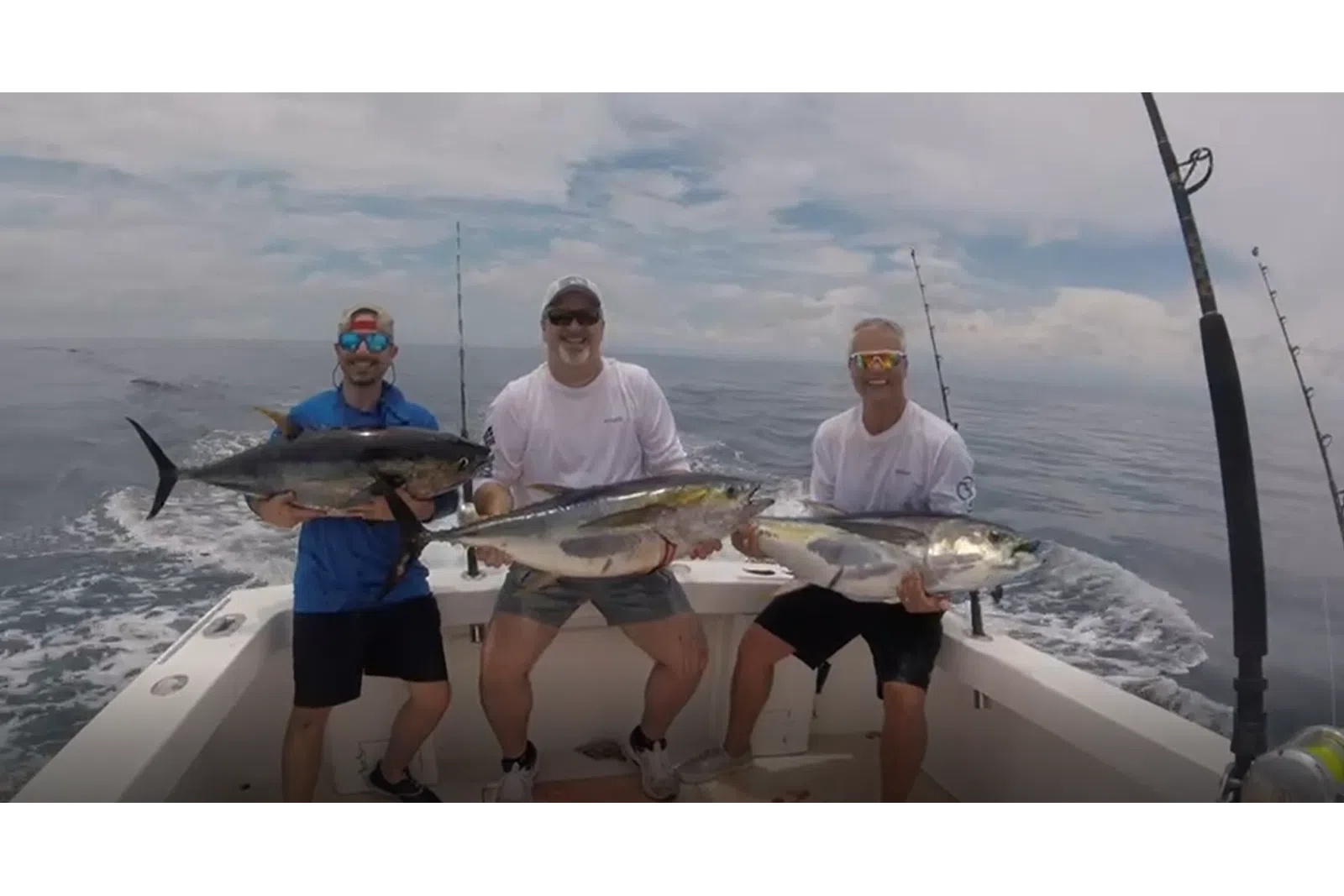 a group of men holding fish on a boat