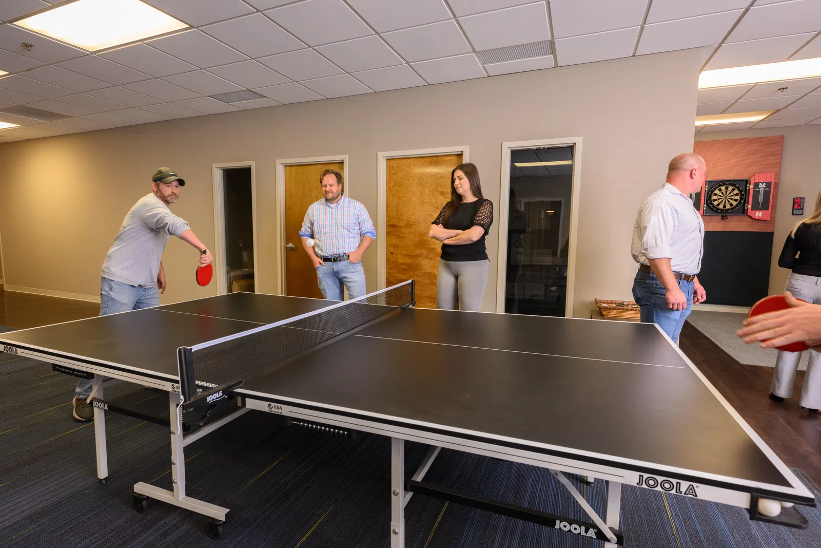 a group of people playing ping pong