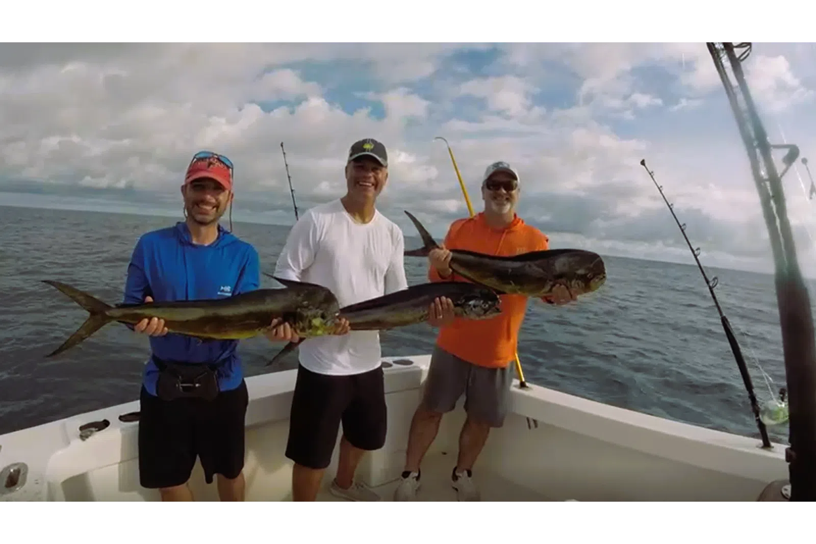 a group of men holding a fish on a boat