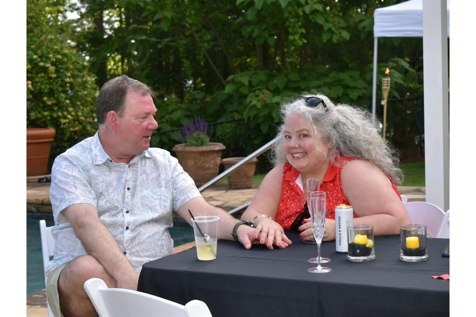 a man and woman sitting at a table outside
