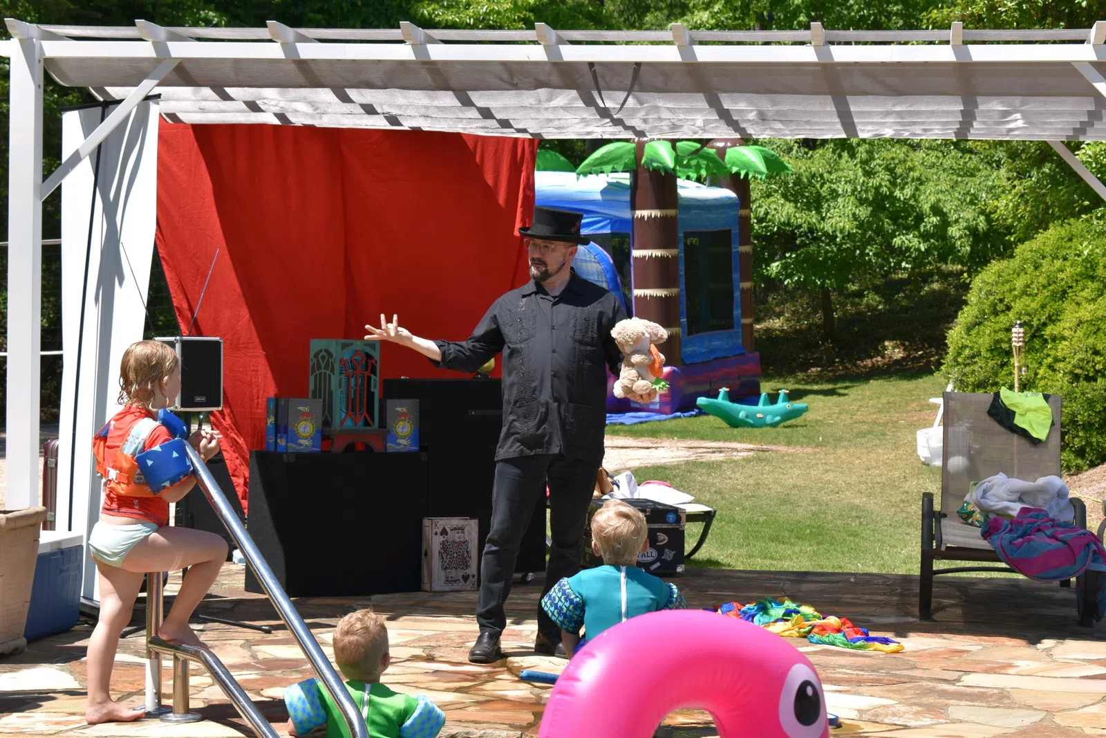 a person standing in front of a tent with kids sitting on the ground