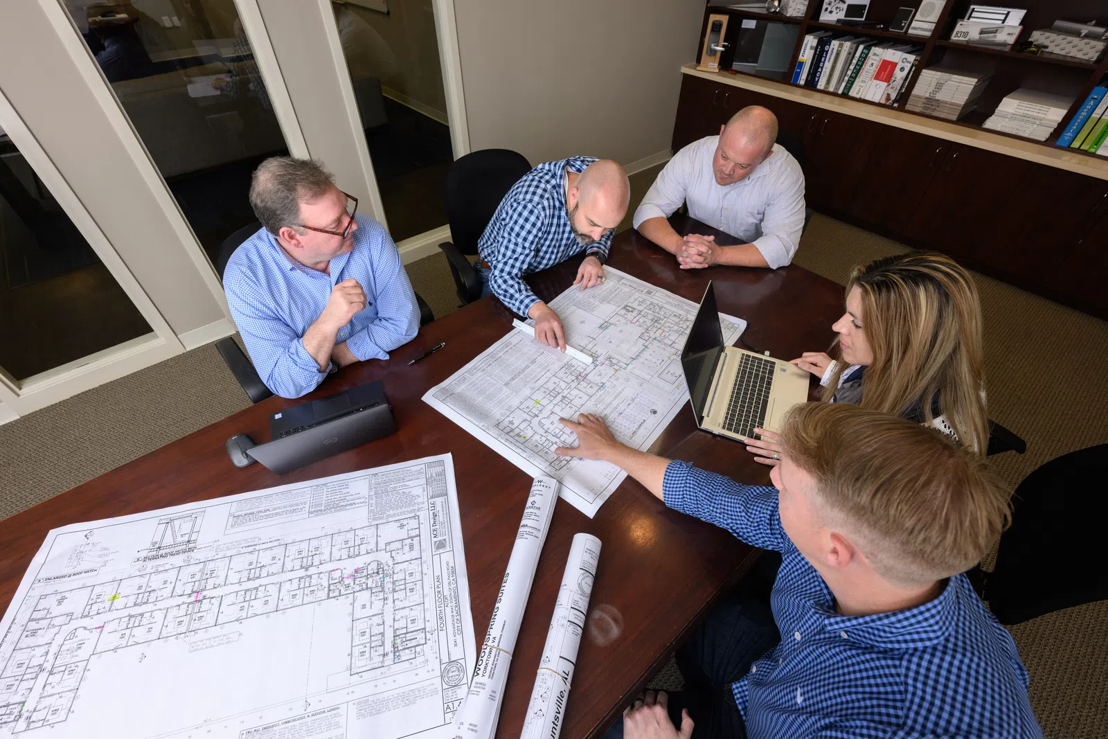 a group of people sitting around a table looking at a book