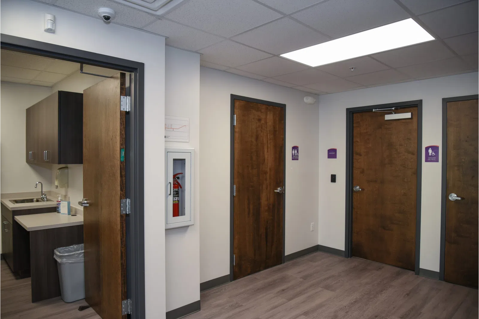 a room with a wood floor and brown doors