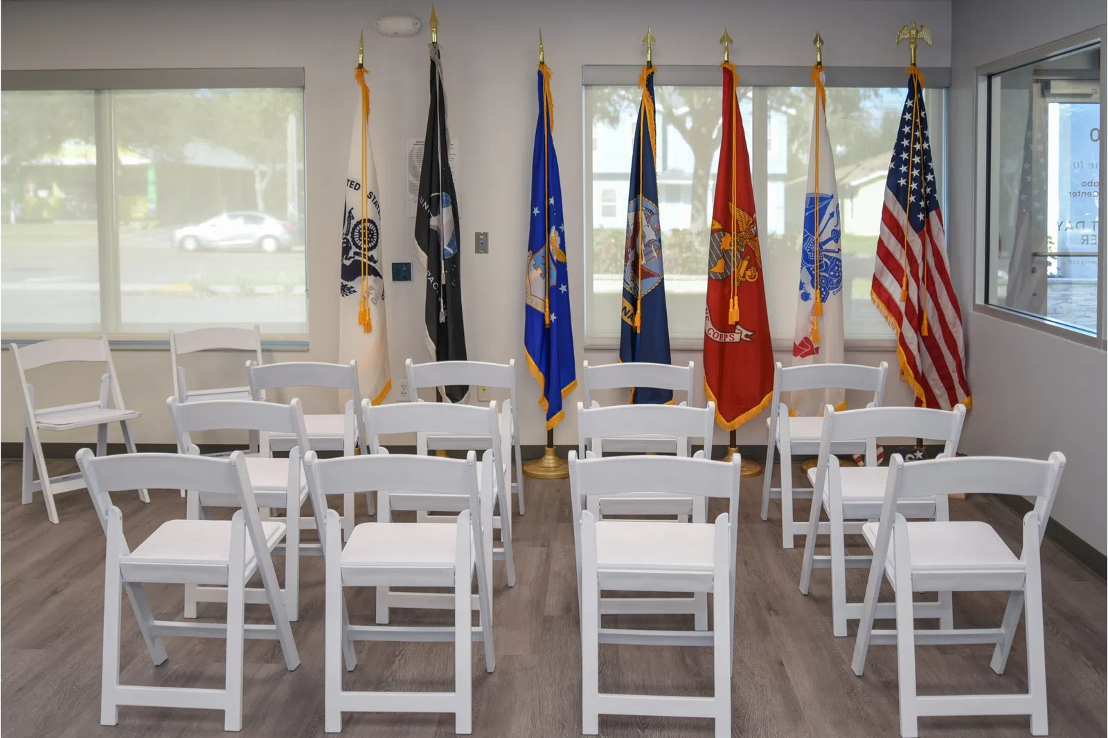 a room with white chairs and flags
