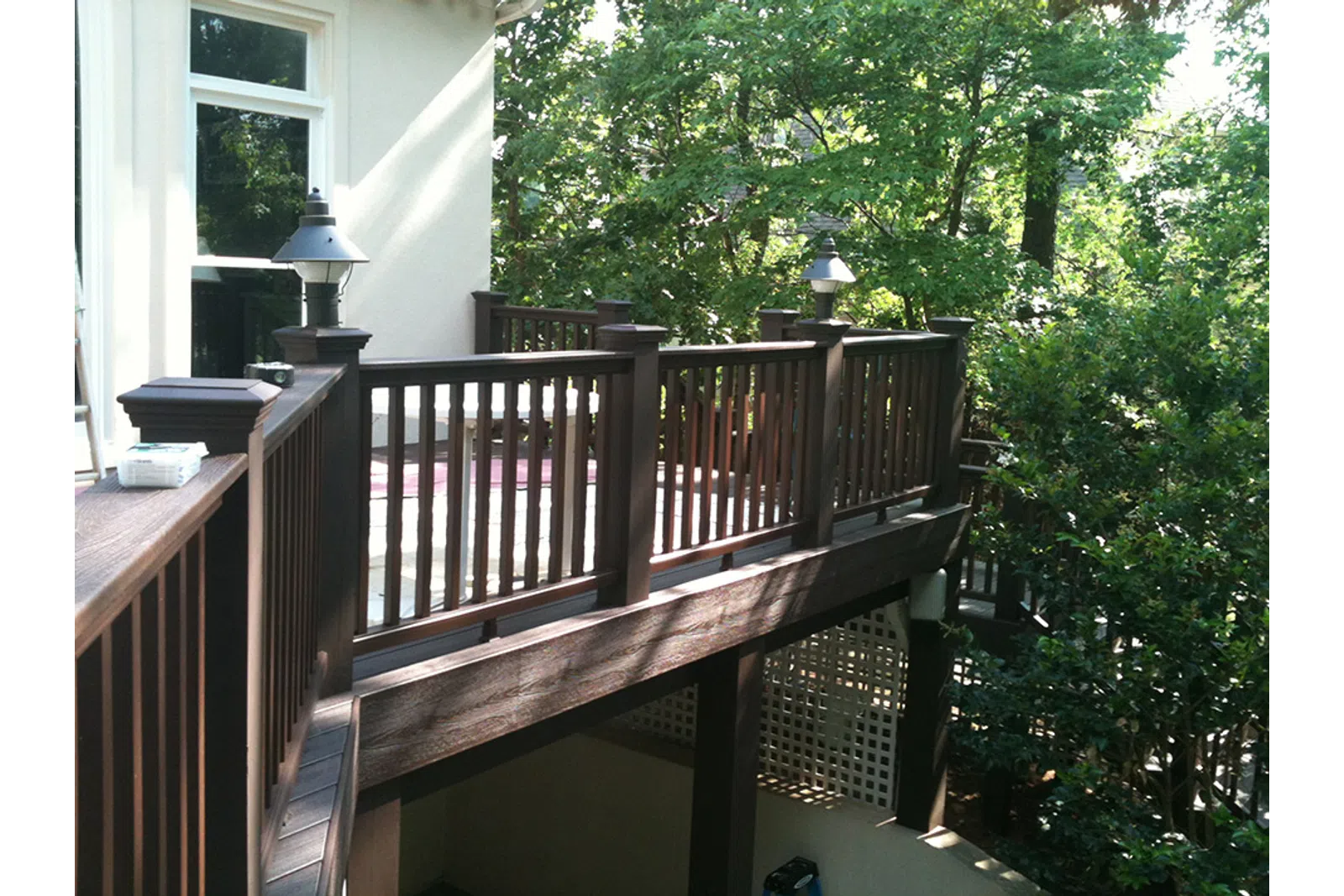 a deck with a railing and trees