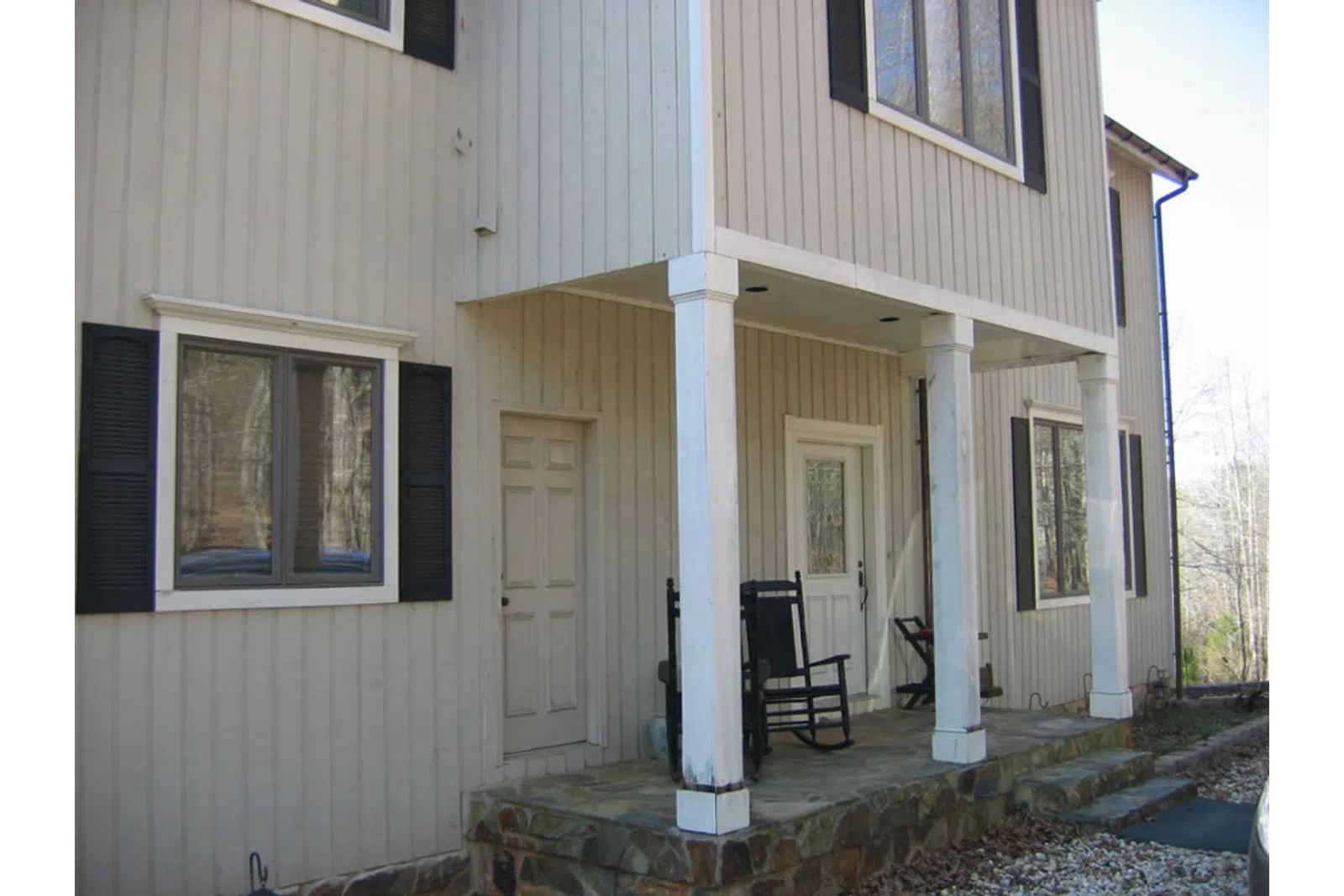 a house with a porch and a chair in the front