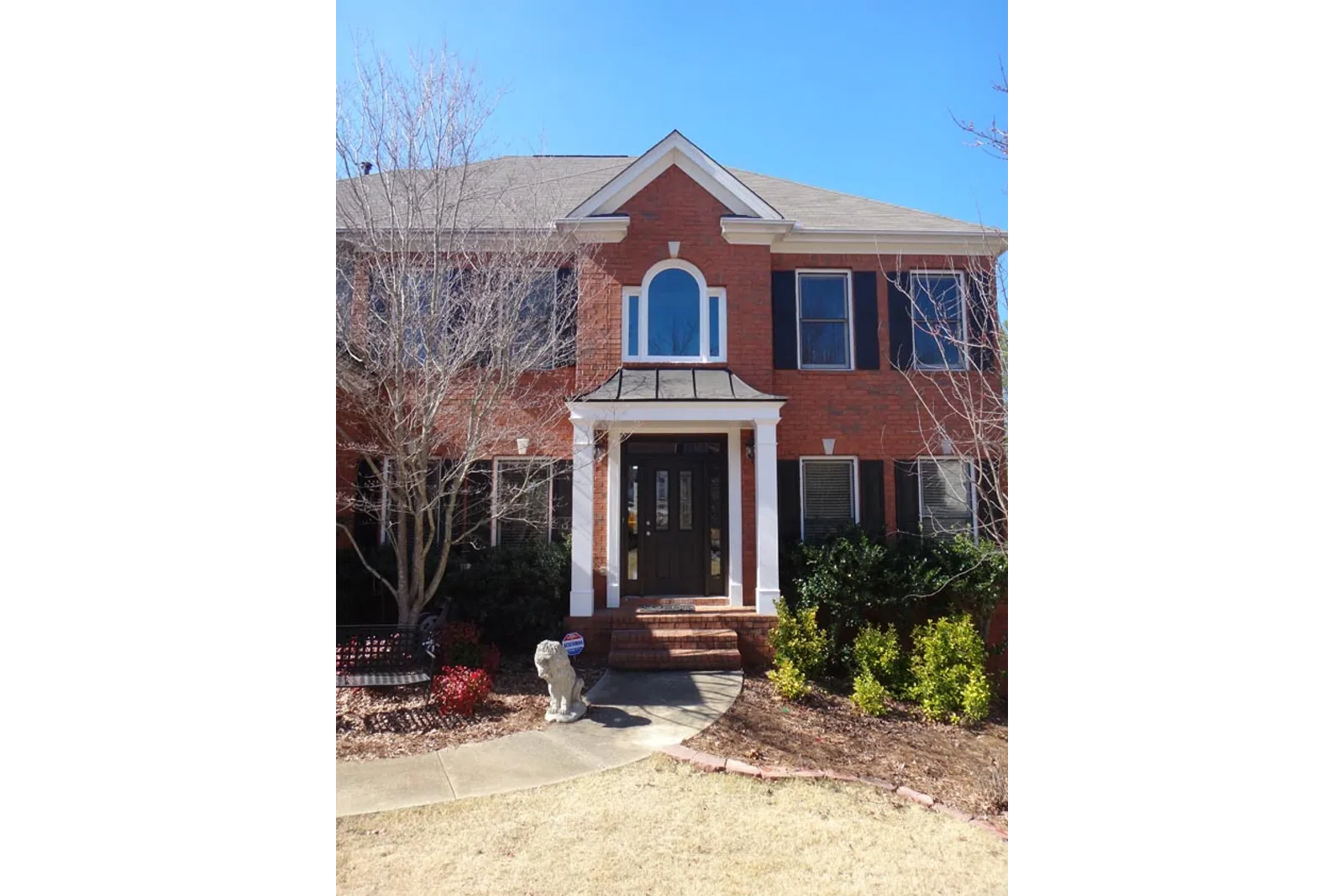 a brick house with a large front yard