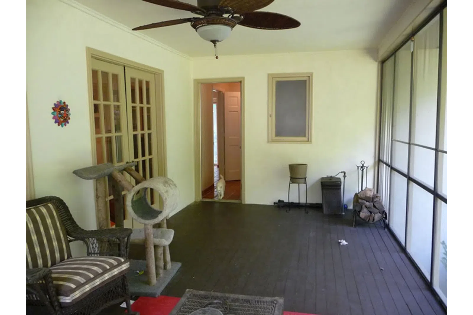 a living room with a fan and chairs