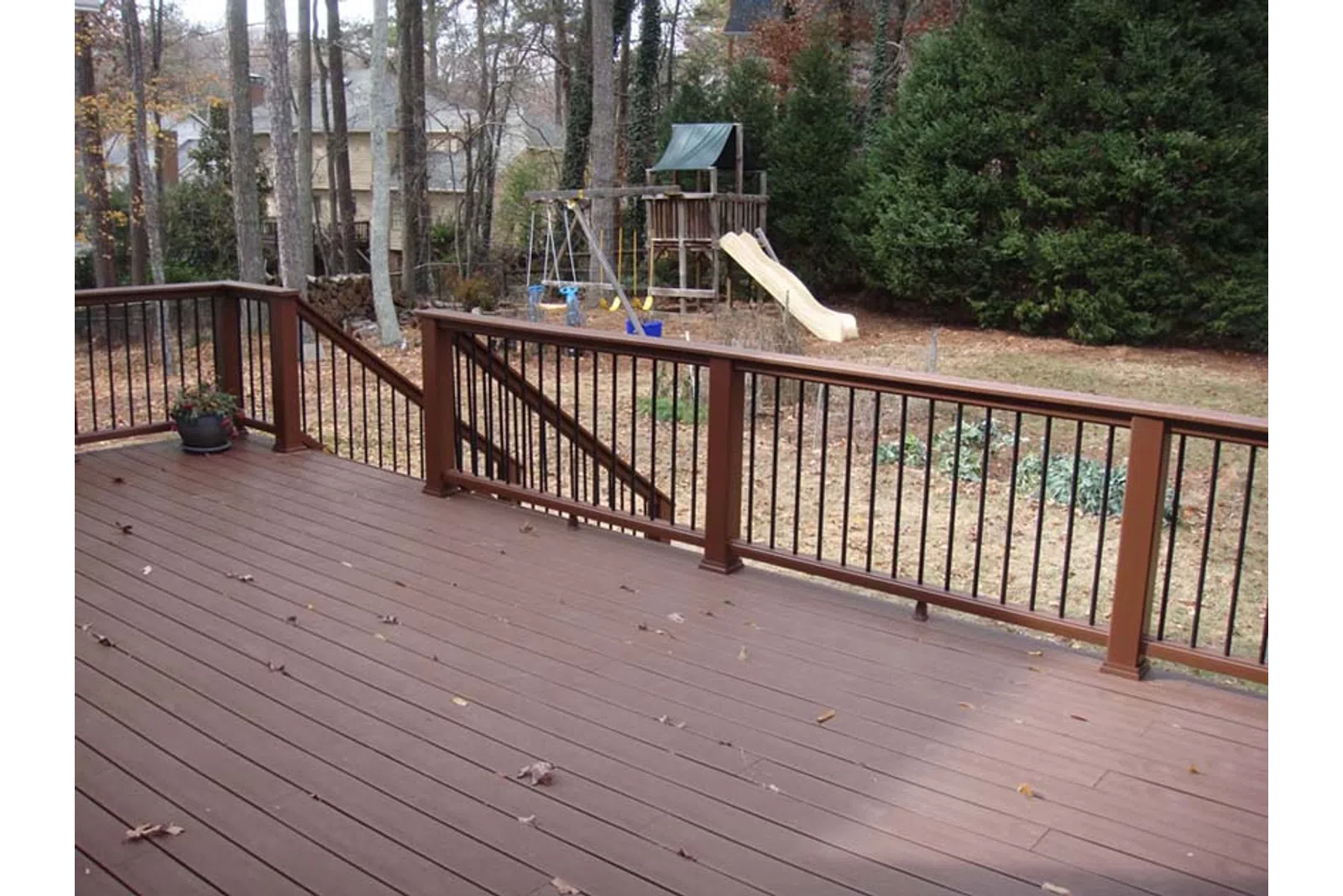 a deck with a slide and trees