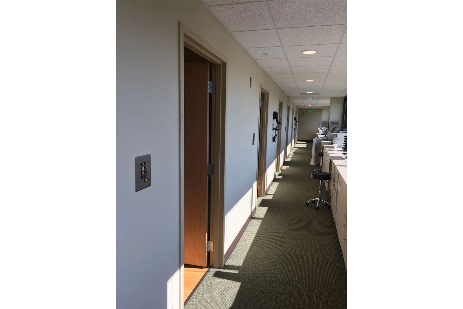 a hallway with a desk and chairs