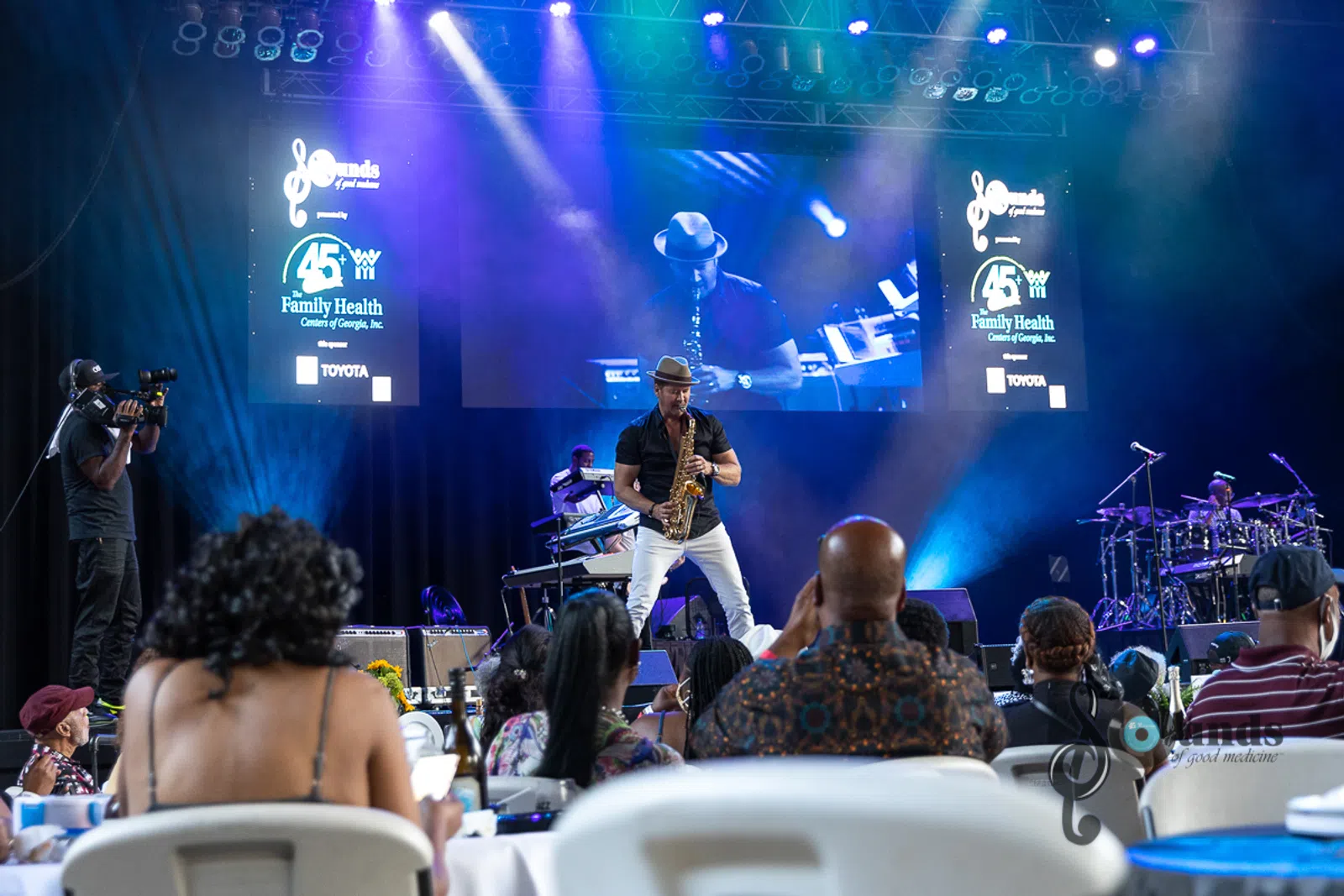 a person sitting on a stage in front of a crowd