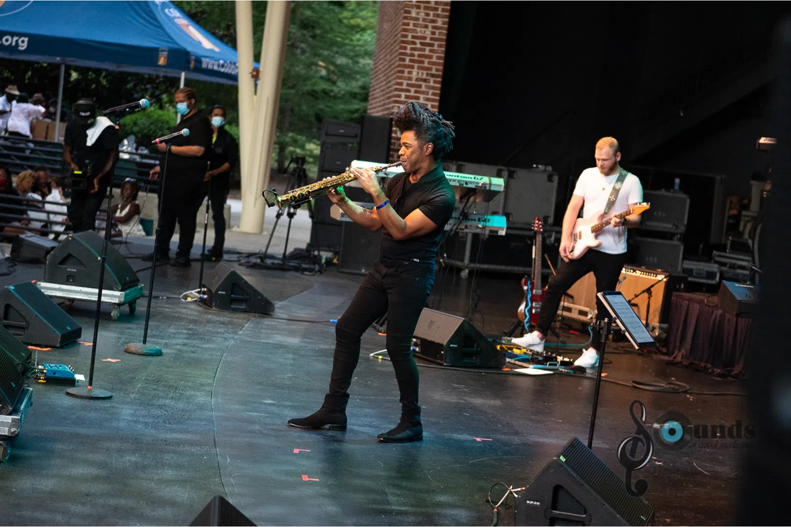 a group of people playing instruments and performing on a stage