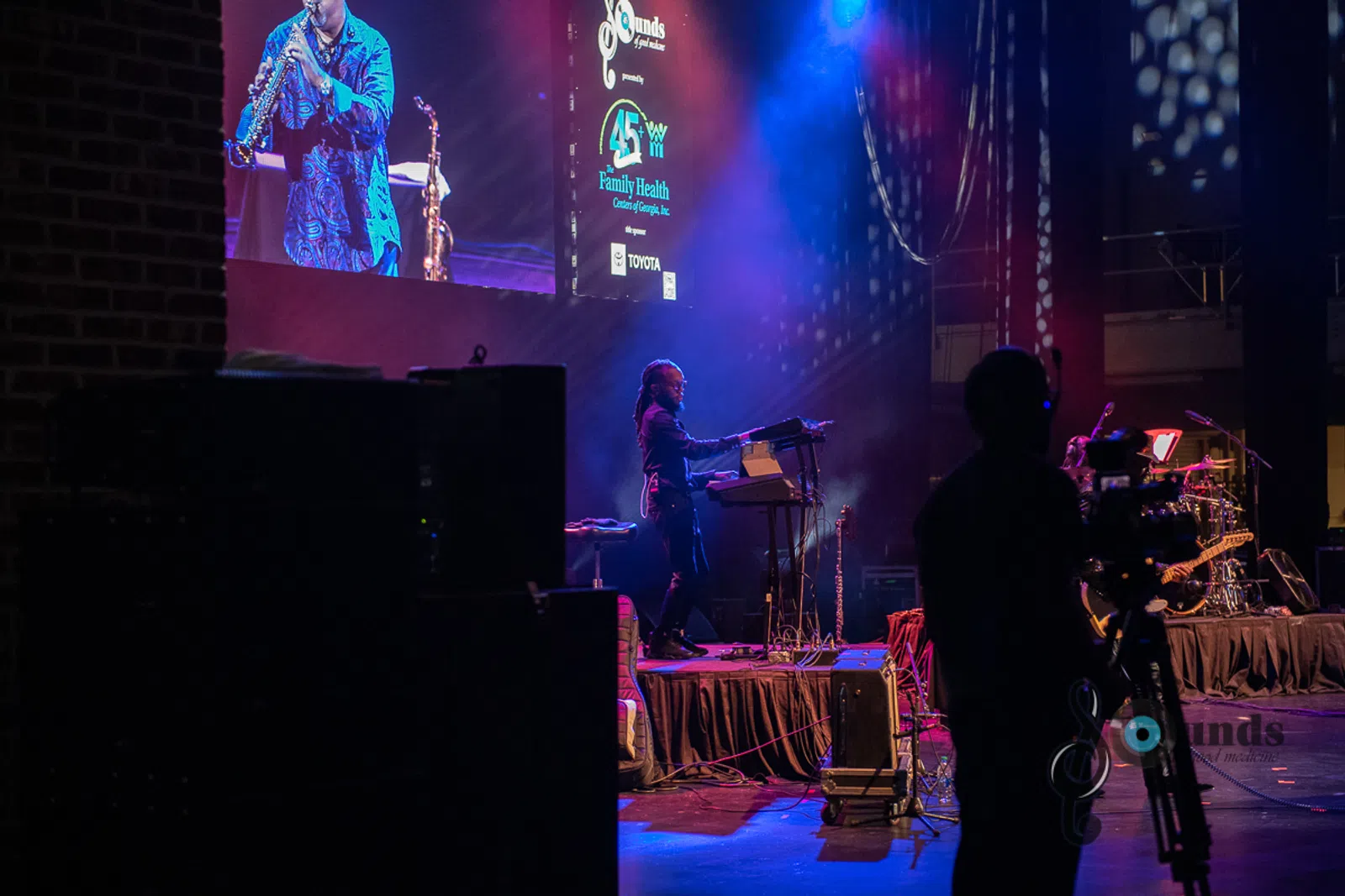 a man standing on a stage in front of a television