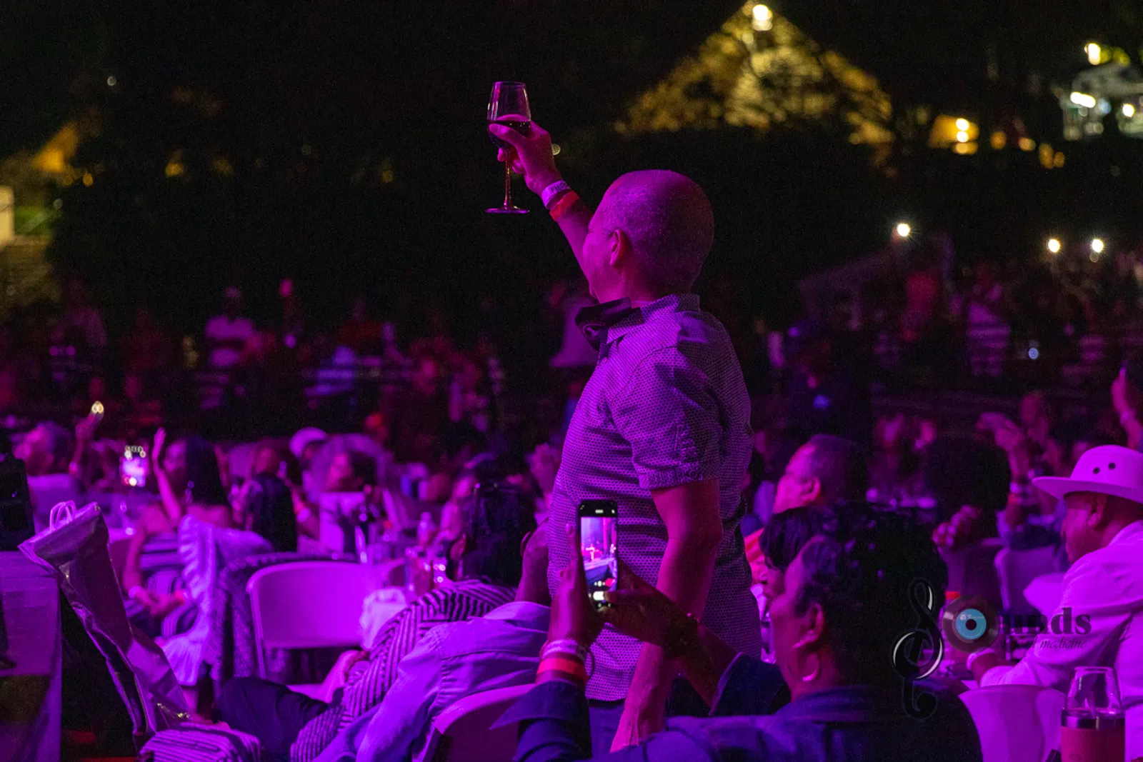 a person sitting on a stage in front of a crowd