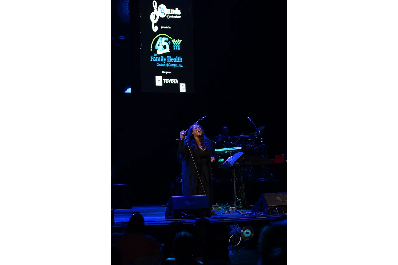 a group of people on a stage in front of a computer screen