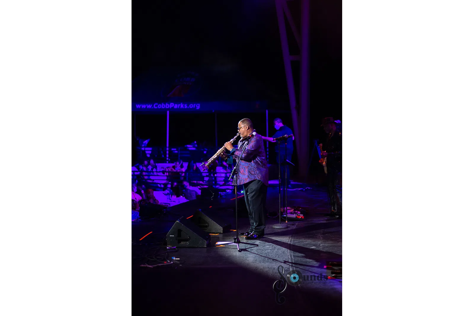 a man standing on a stage playing instruments